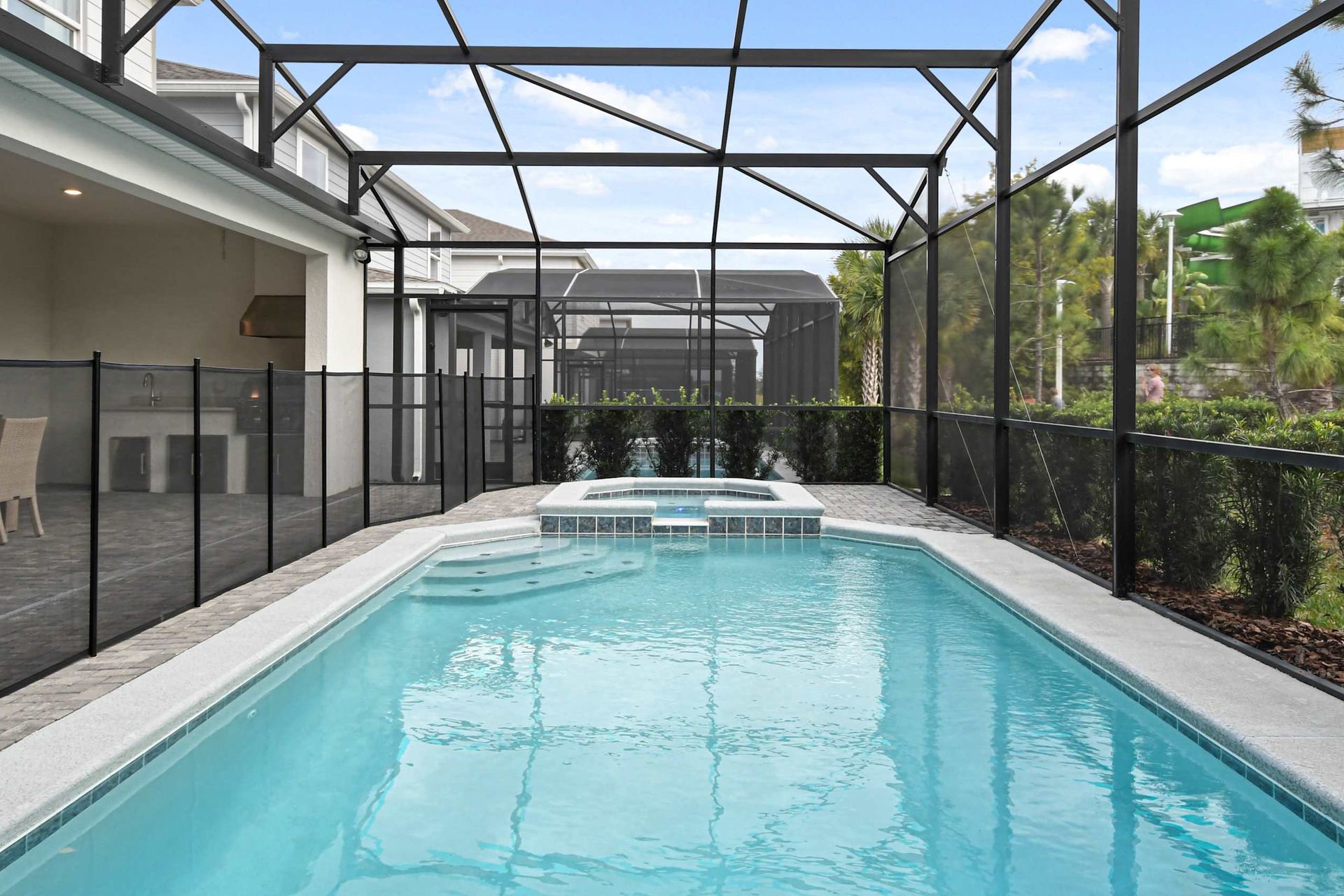 Private screened-in pool and spa with outdoor dining, lounge space, and lush views!