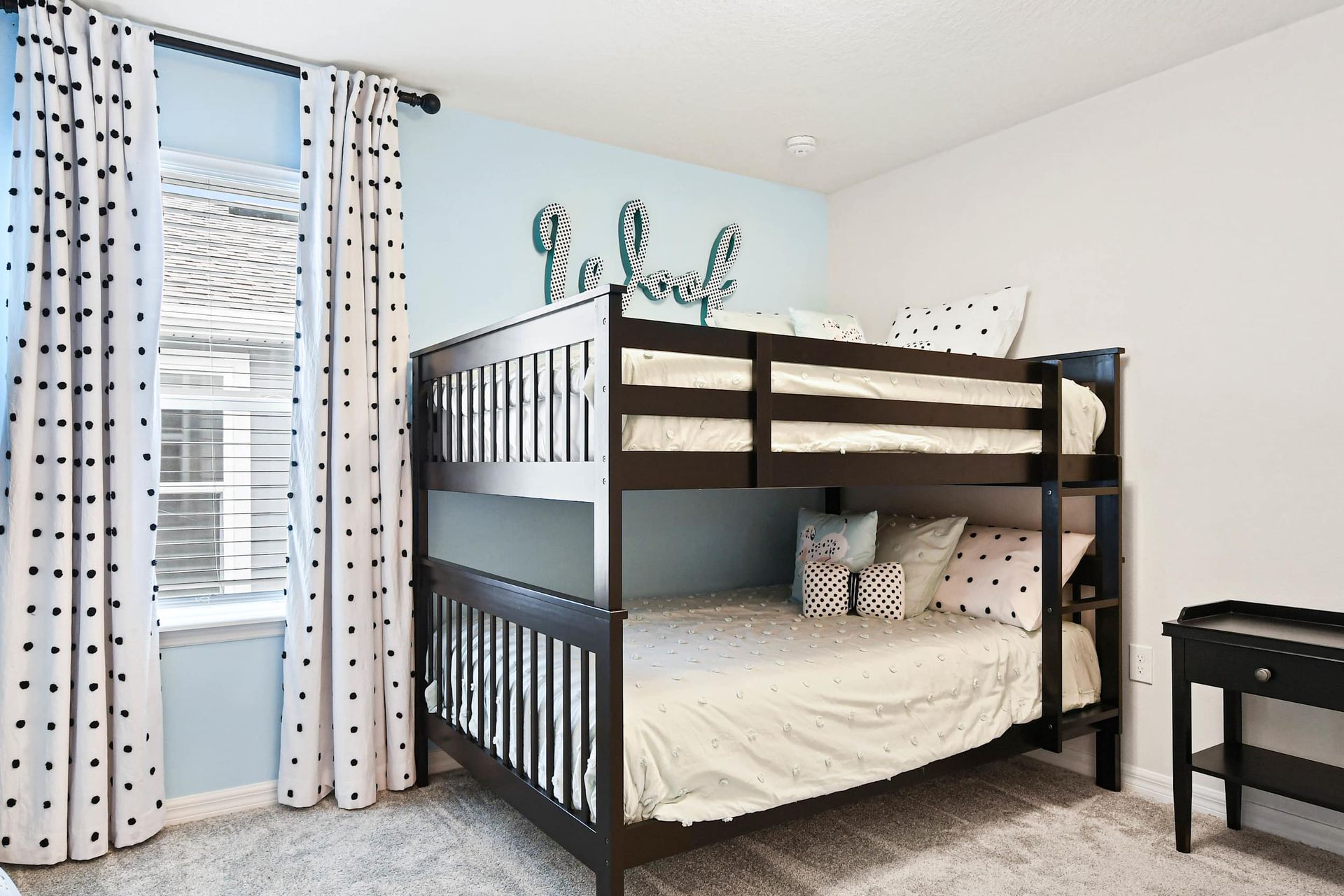 Charming bunk room with playful polka dots, cozy bedding, and a stylish touch!