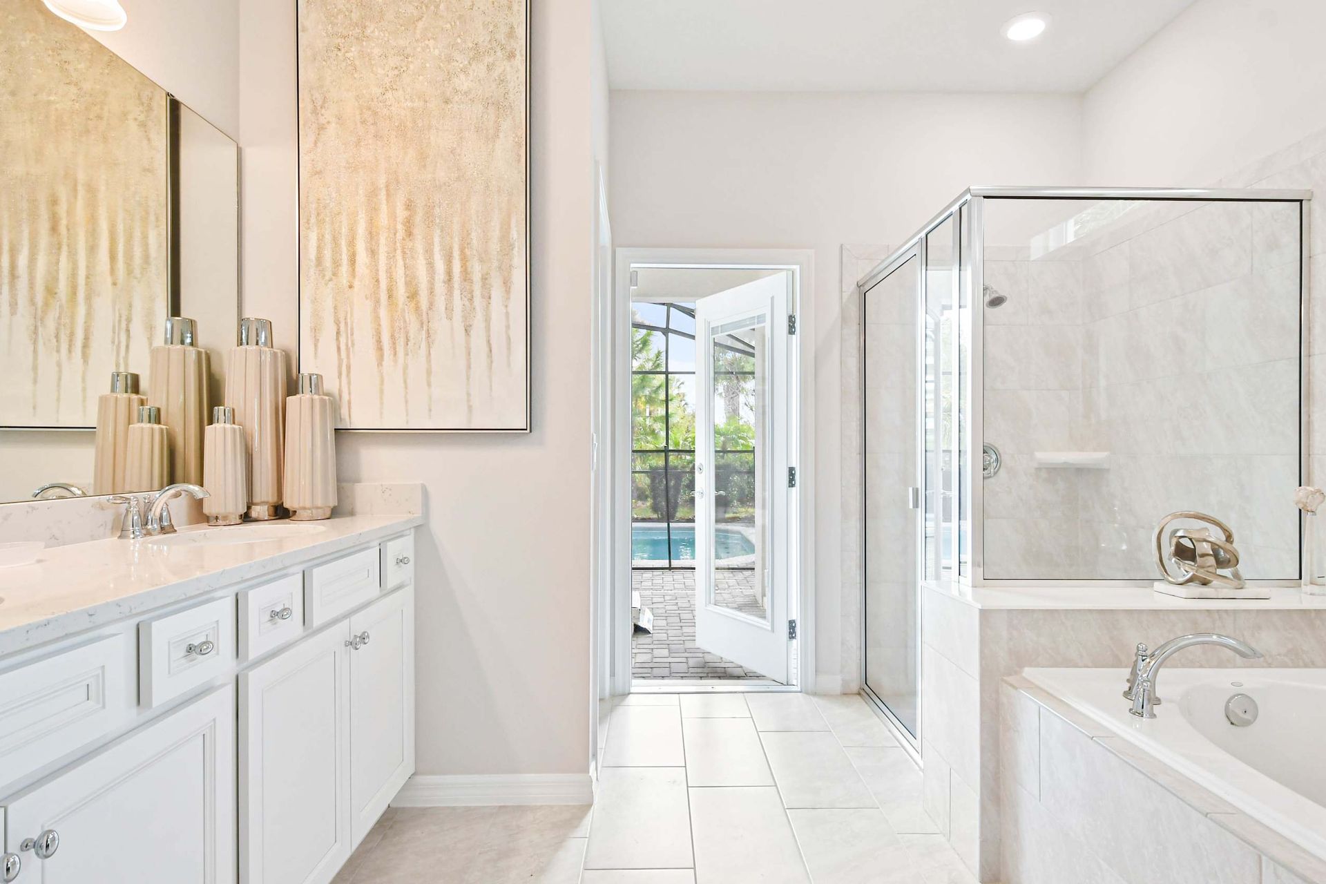 Luxurious spa-like bathroom with dual vanities, a soaking tub, and pool access!