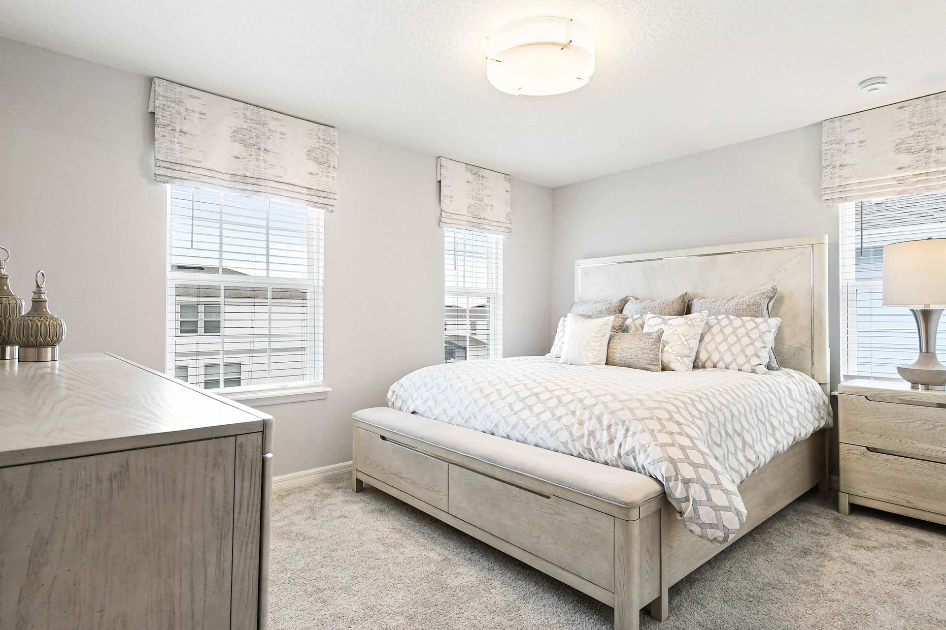 Elegant bedroom with soft neutrals, plush bedding, and abundant natural light!