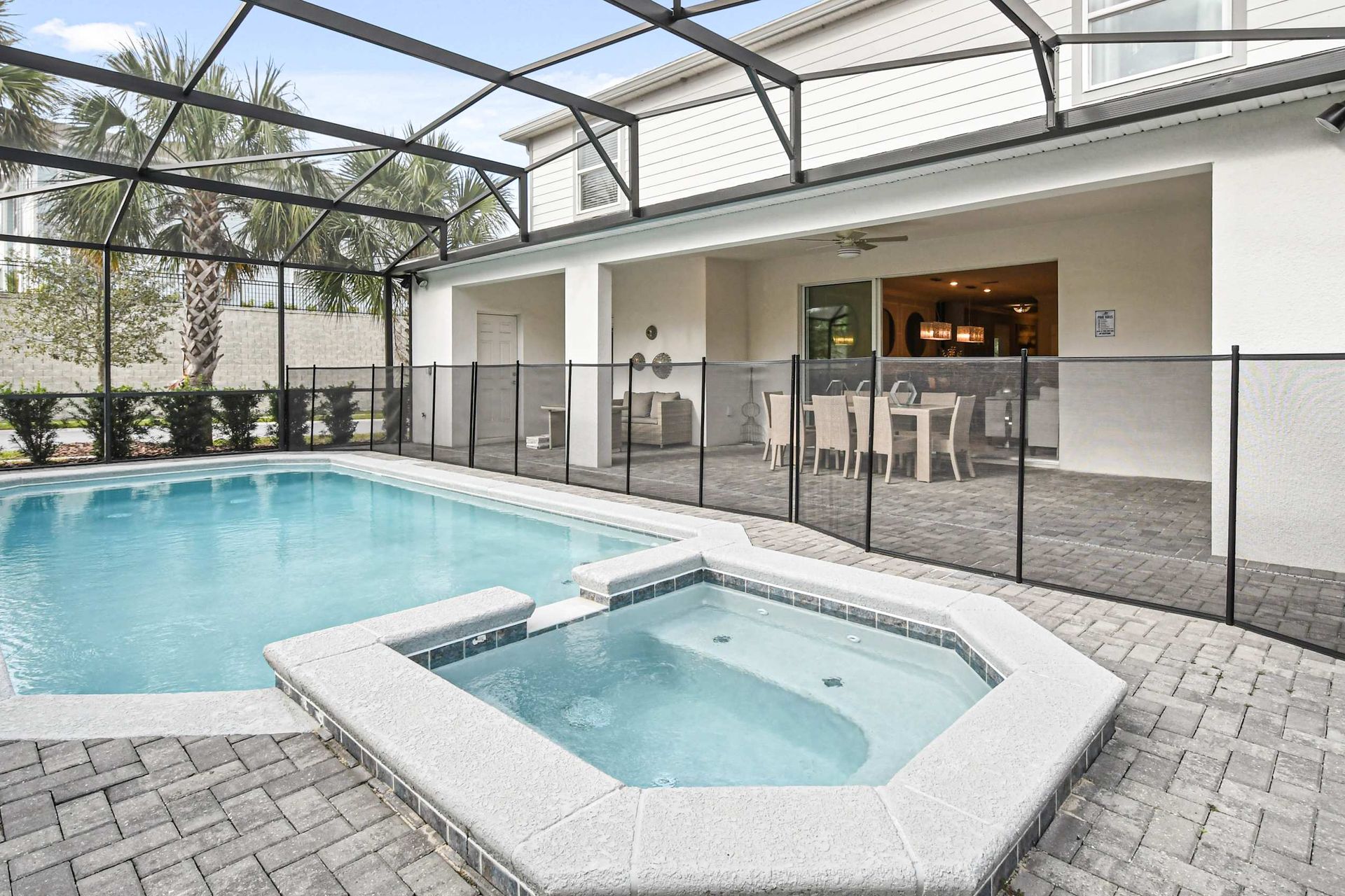 Private screened-in pool and spa with outdoor dining, lounge space, and lush views!
