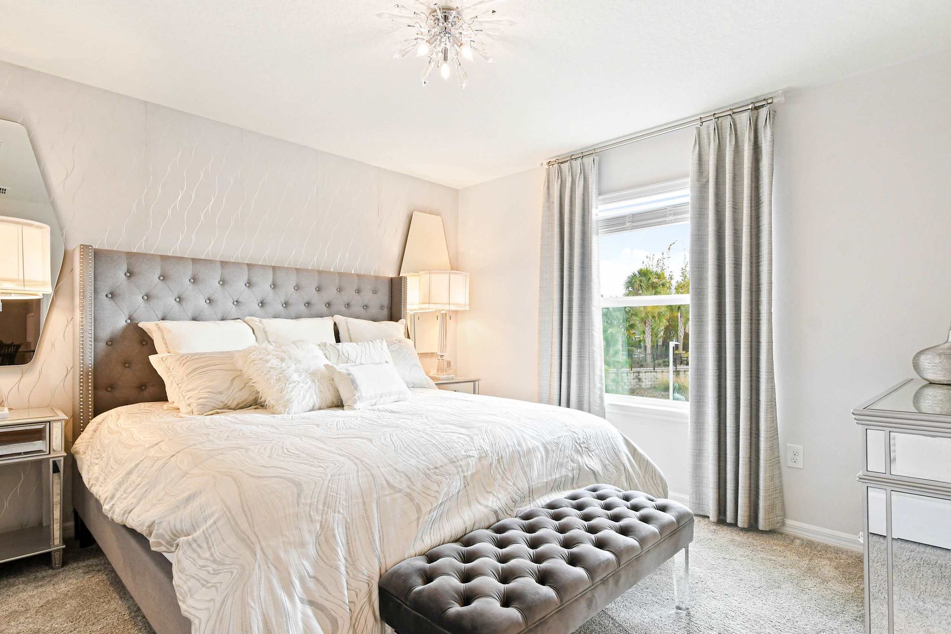 Luxurious bedroom with elegant decor, plush bedding, and a stunning chandelier!