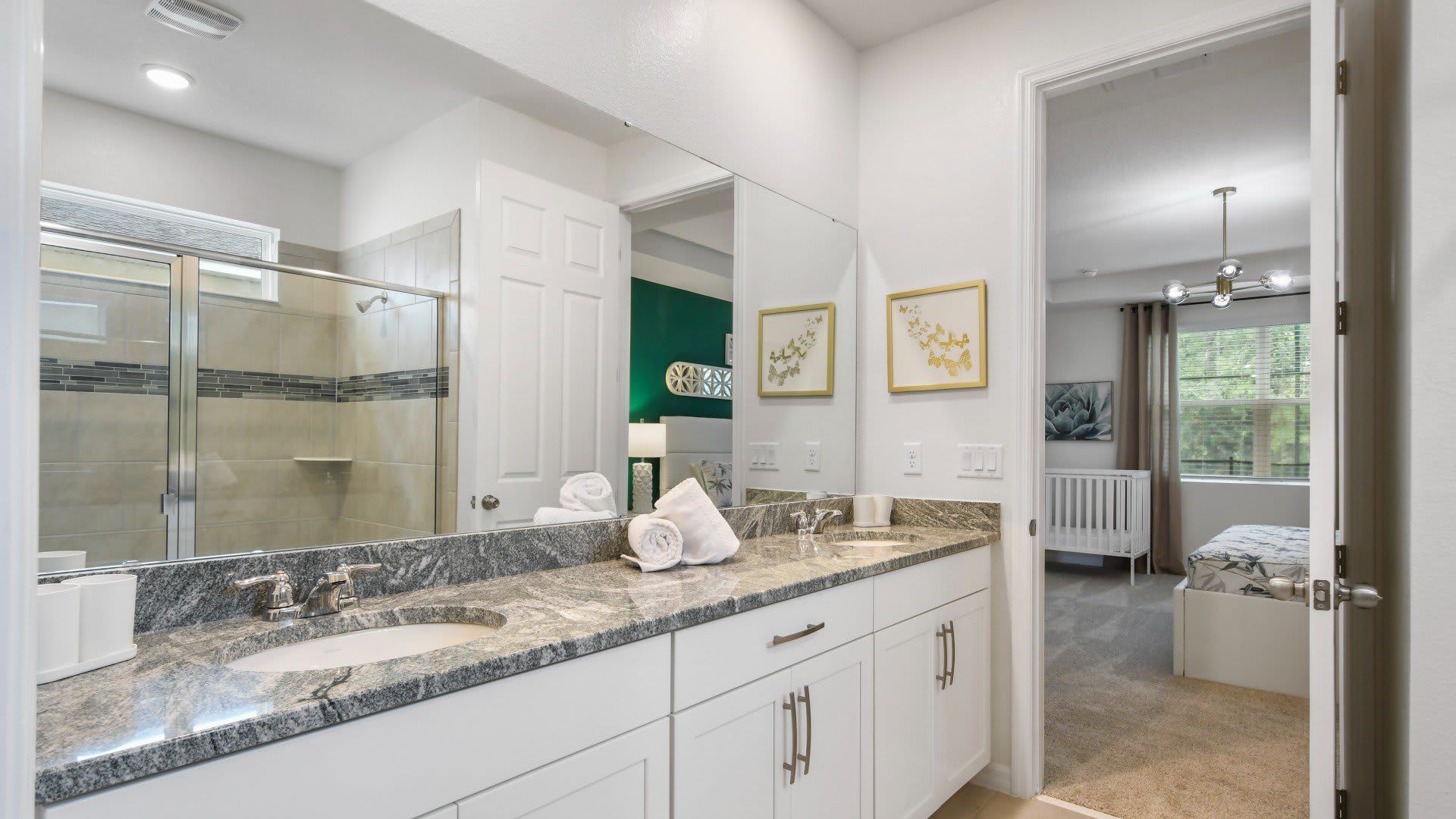 Stylish ensuite bathroom with dual sinks, granite countertops, and a glass shower! 