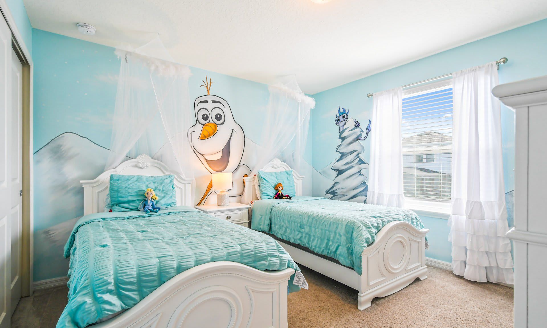 Charming Frozen-themed room with twin beds, wintery wall art, and snow-white curtains for a magical vibe.