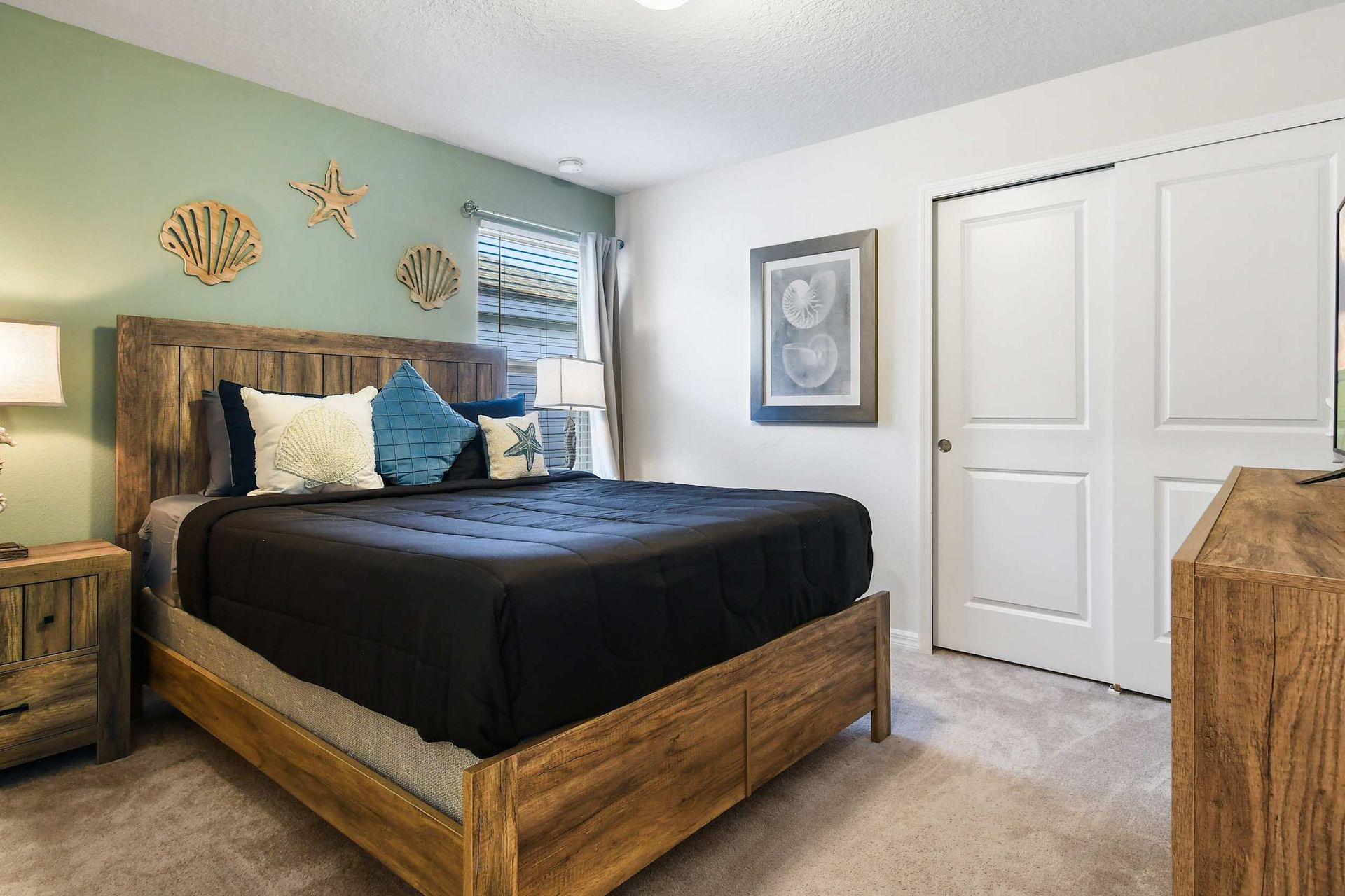 Coastal-themed bedroom with a queen bed, beachy decor, and smart TV for a relaxing stay.