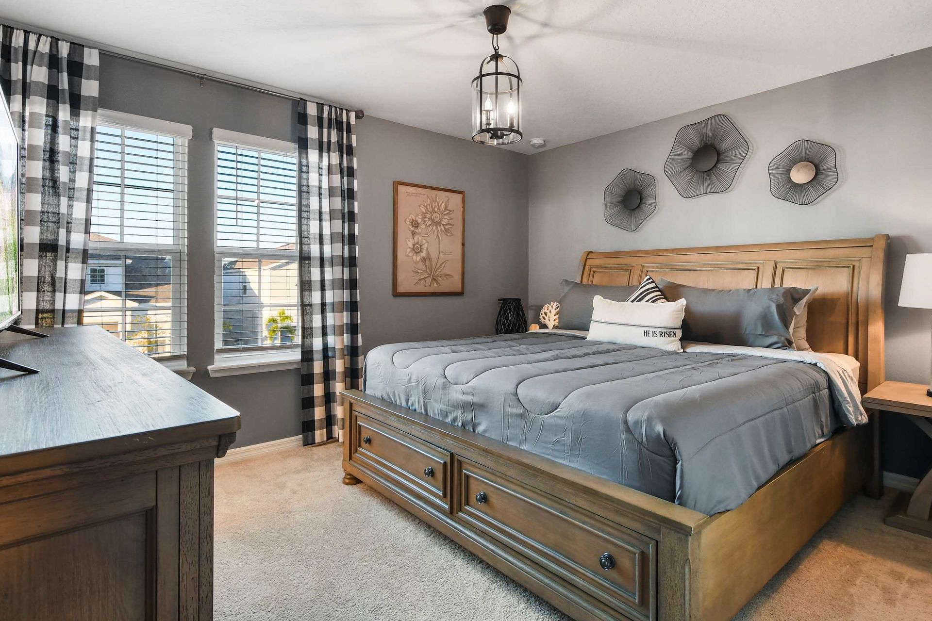 Cozy master bedroom with a king bed, stylish decor, natural light, and a smart TV for relaxation.