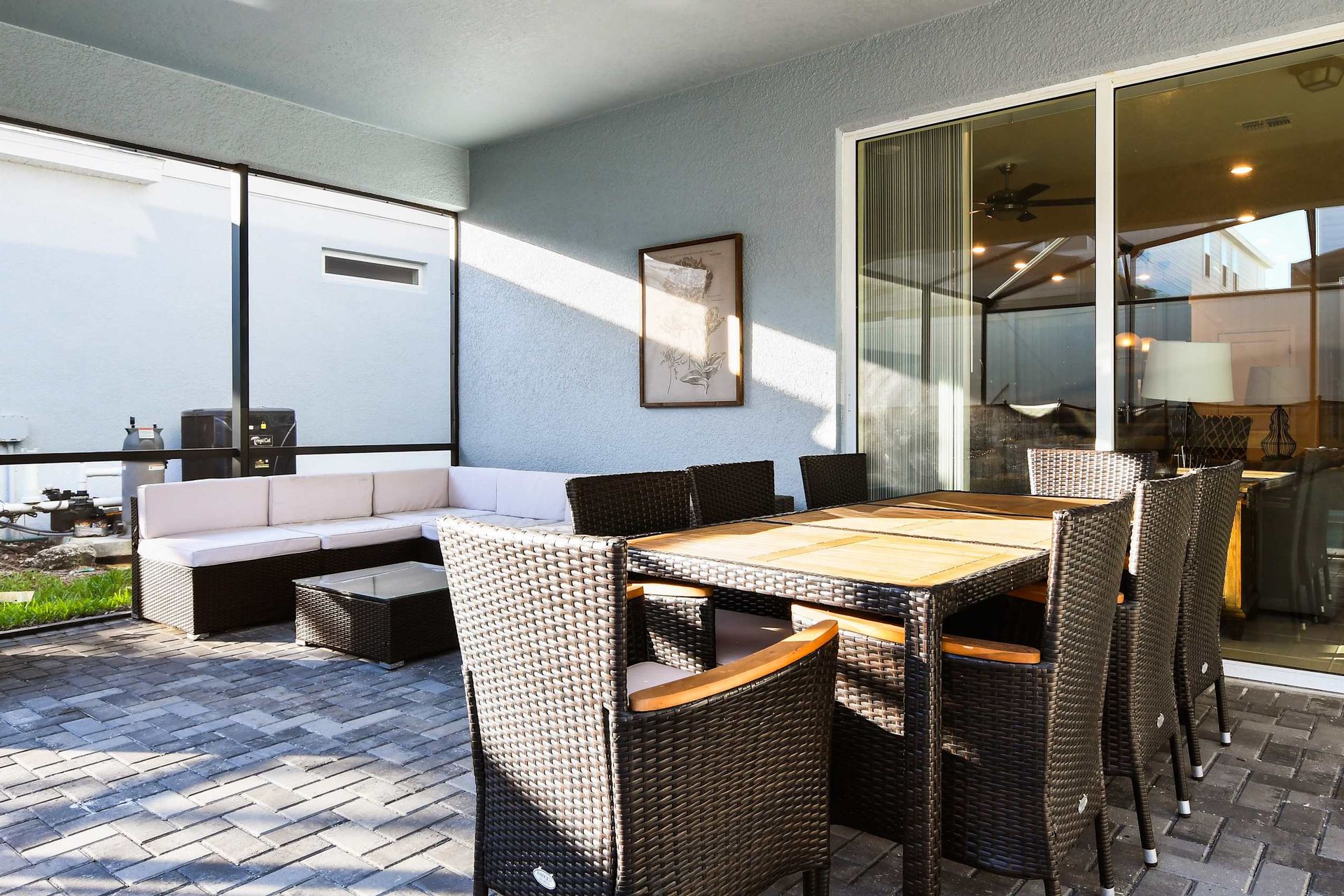 Relaxing screened patio with a comfy sectional, dining table for 8, and shaded outdoor seating.