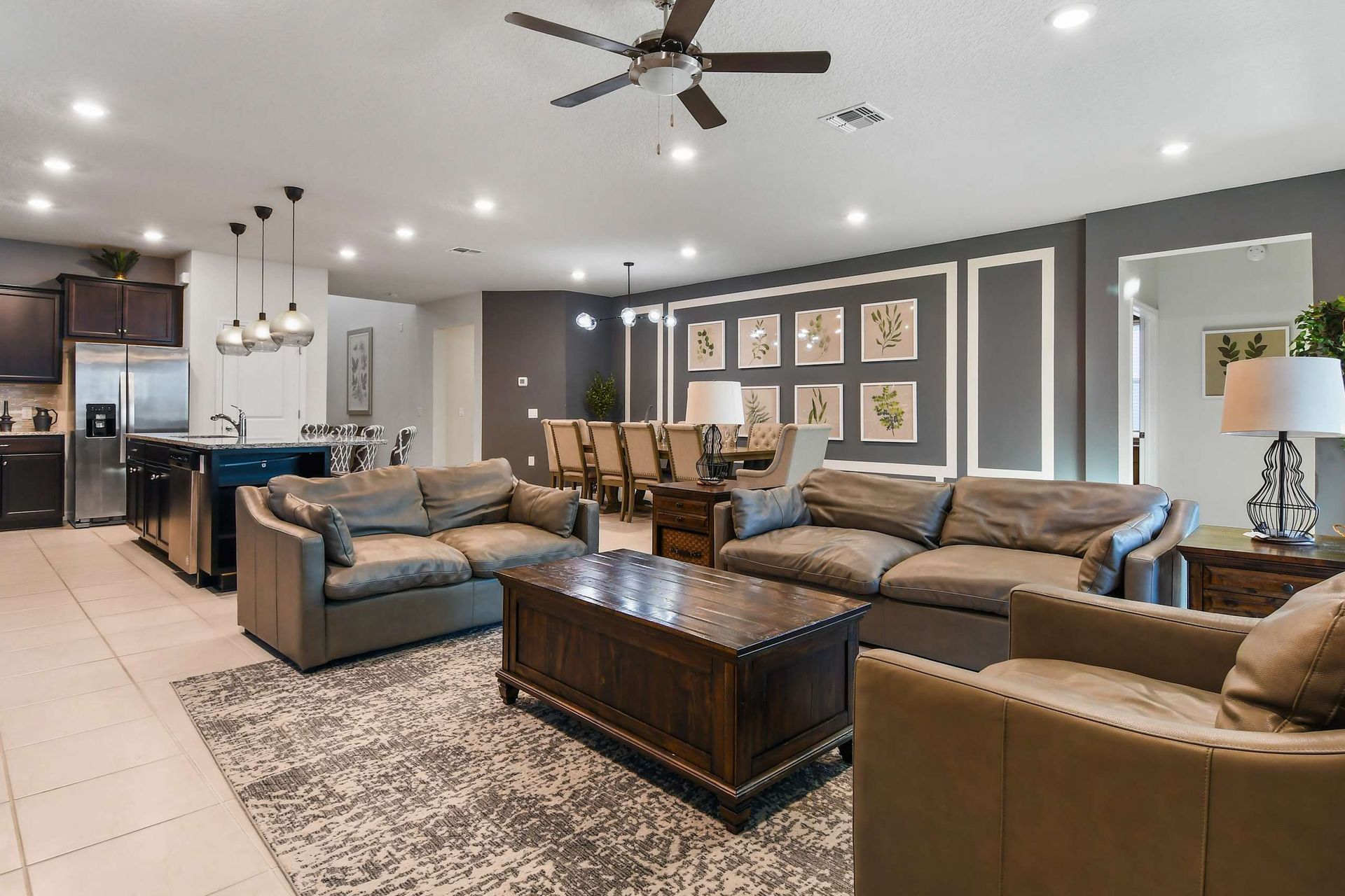 Modern open-concept living space with leather seating, gourmet kitchen, and elegant dining area.