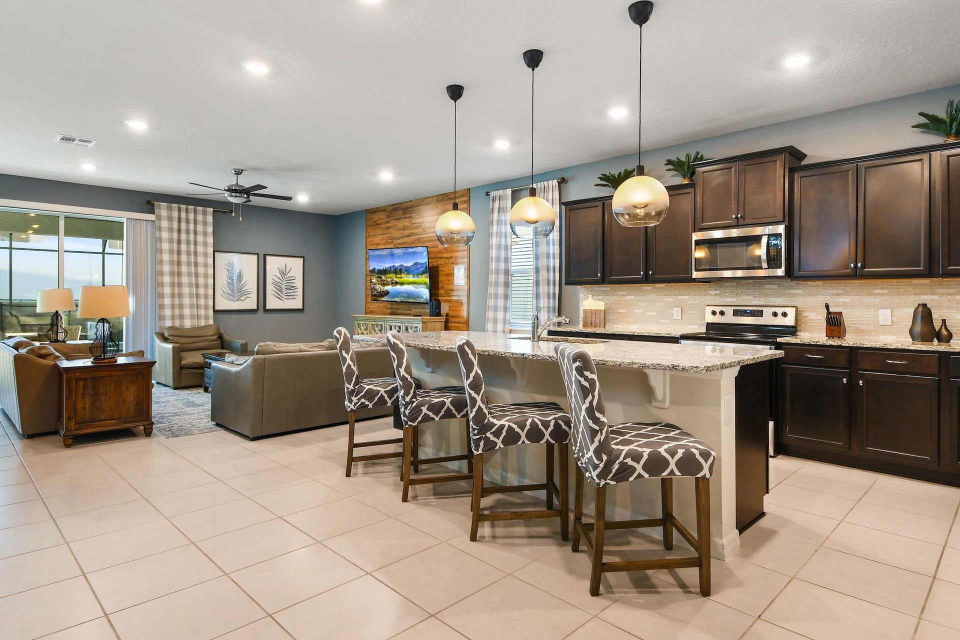 Beautiful open kitchen with granite countertops, stylish pendant lighting, and bar seating overlooking the living area.