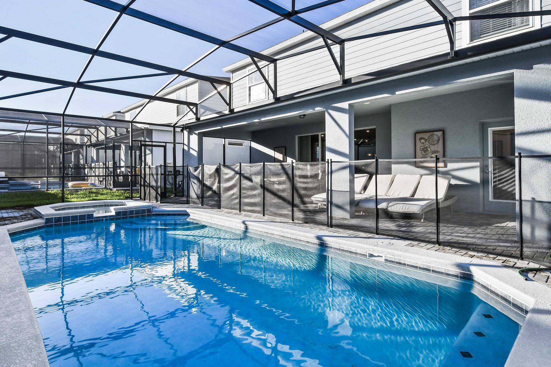 Enclosed private pool and spa with lounge chairs for a perfect relaxing retreat.