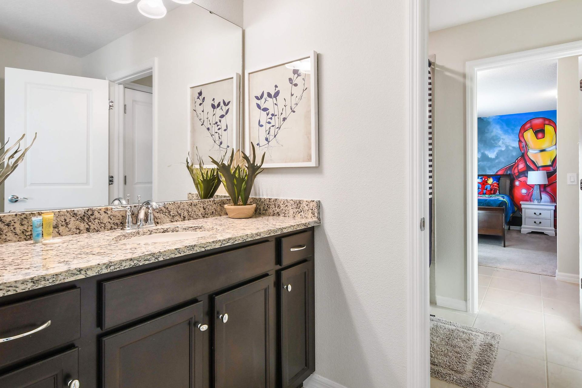 Modern shared bathroom with granite vanity and bright, stylish decor.