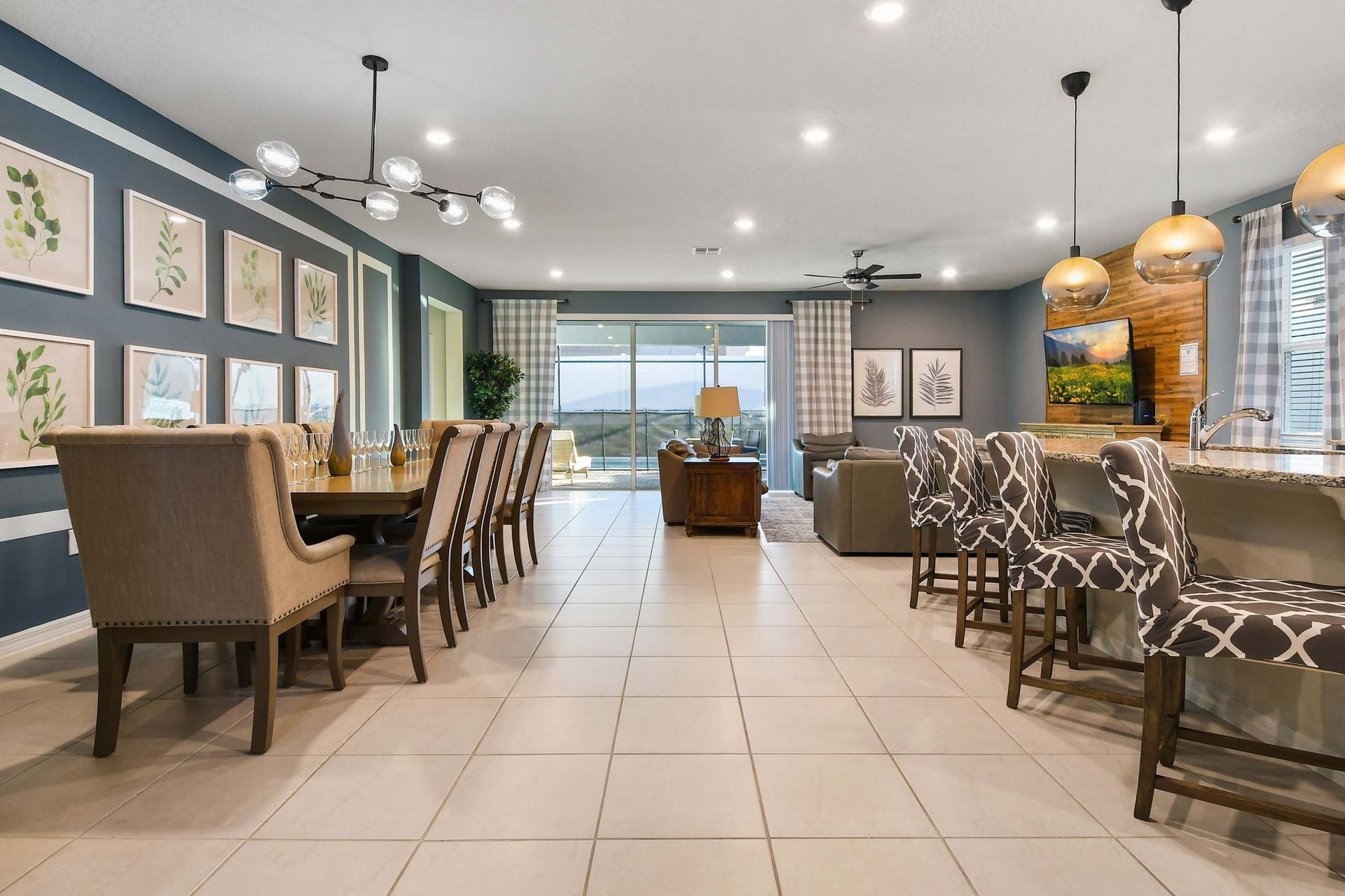 Spacious open-concept living and dining area with stylish decor, modern kitchen, and pool view.