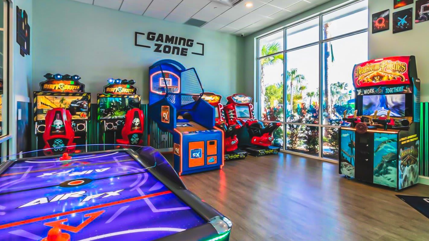 Exciting gaming zone with arcade games, air hockey, racing simulators, and basketball hoops.