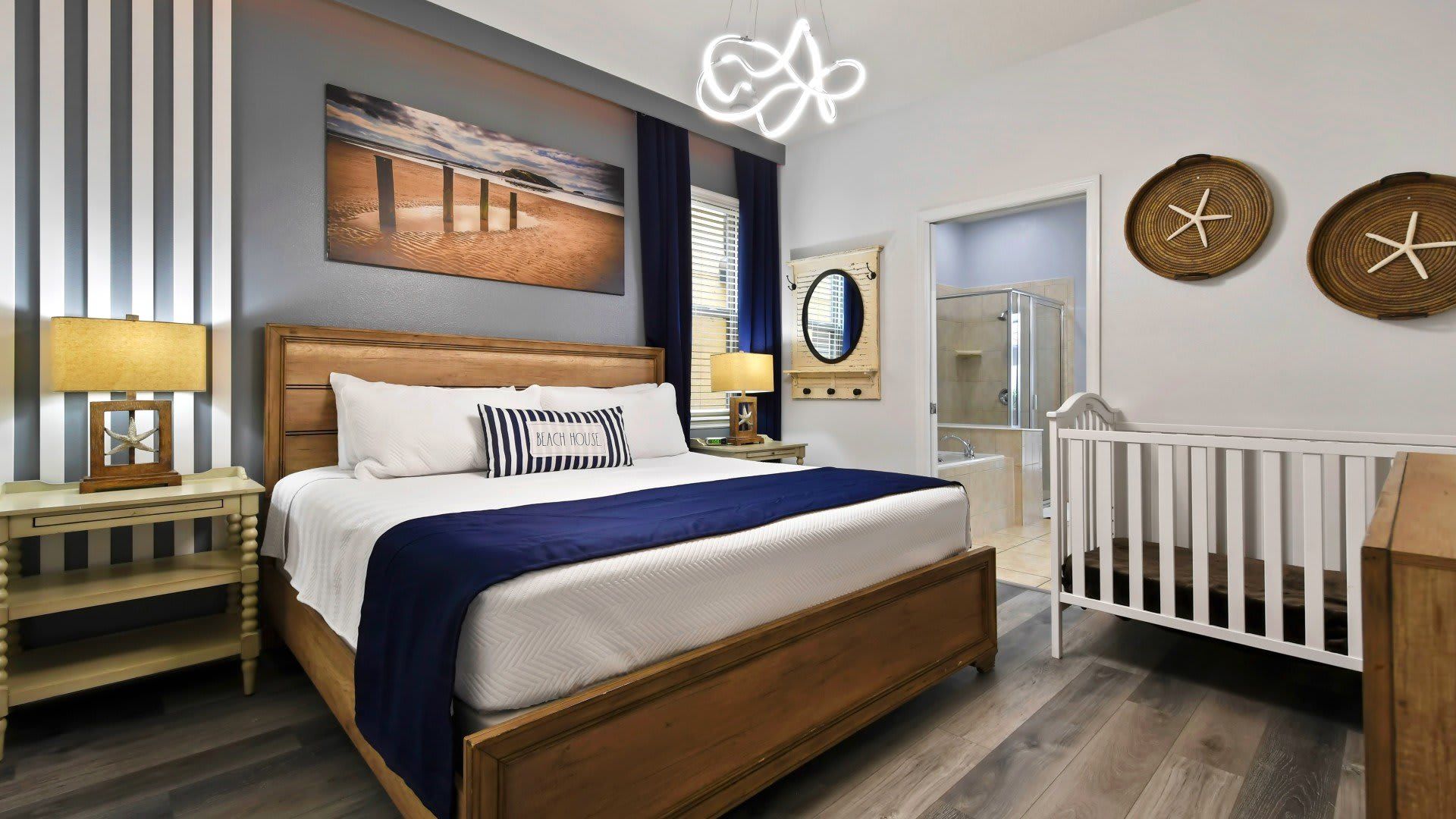 The master bedroom features a luxuriously large king bed with a crib