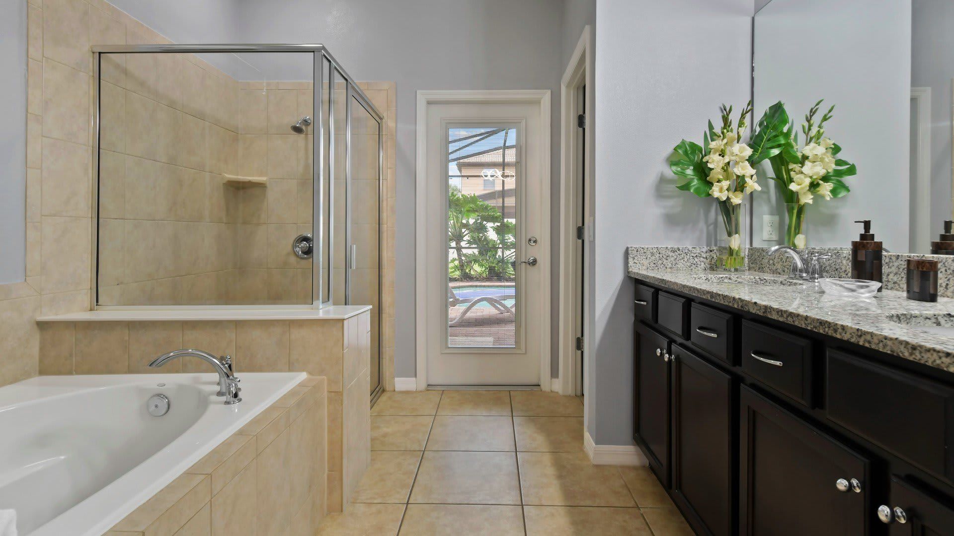 Elegant spa-like bathroom with a soaking tub, walk-in shower & direct pool access!