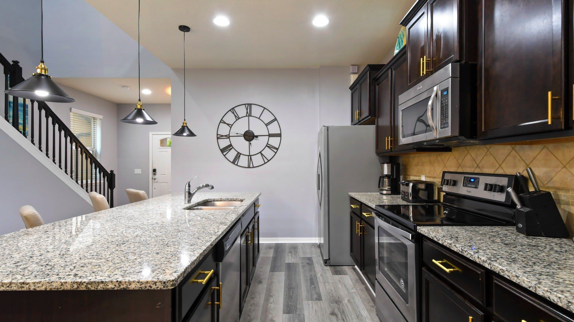 Stylish modern kitchen with granite countertops, sleek lighting & gourmet vibes!