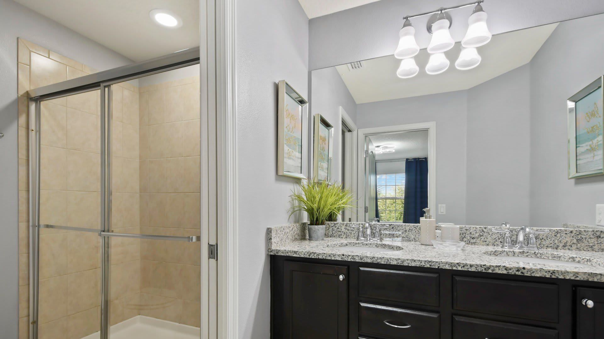 Modern bathroom with dual sinks, granite countertops & a sleek glass walk-in shower!