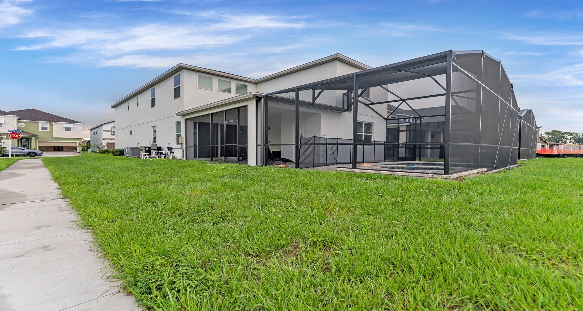 Spacious backyard with a screened-in pool, covered patio, and plenty of green space!