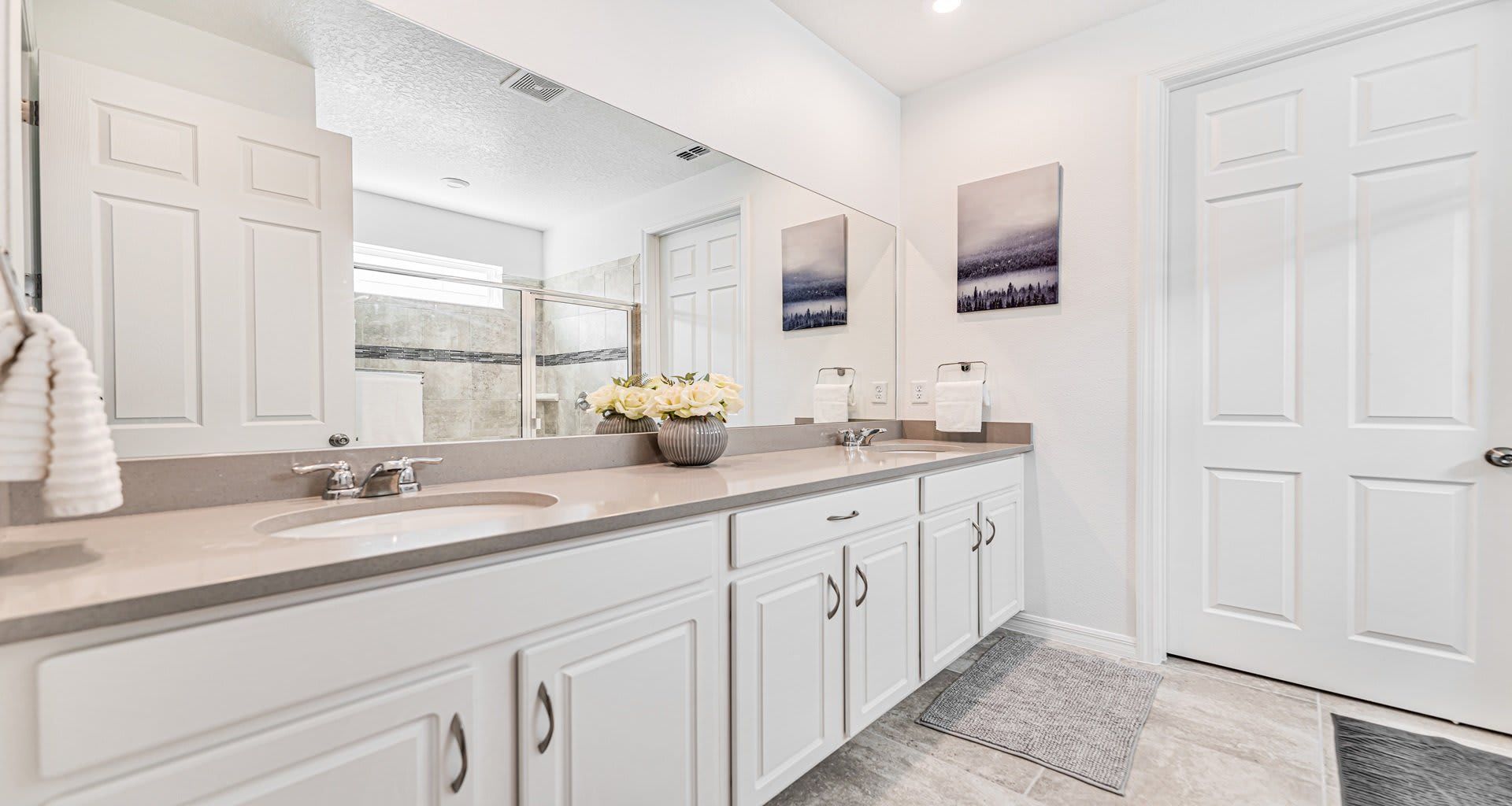 Elegant and spacious bathroom with dual sinks, modern finishes, and a glass shower!