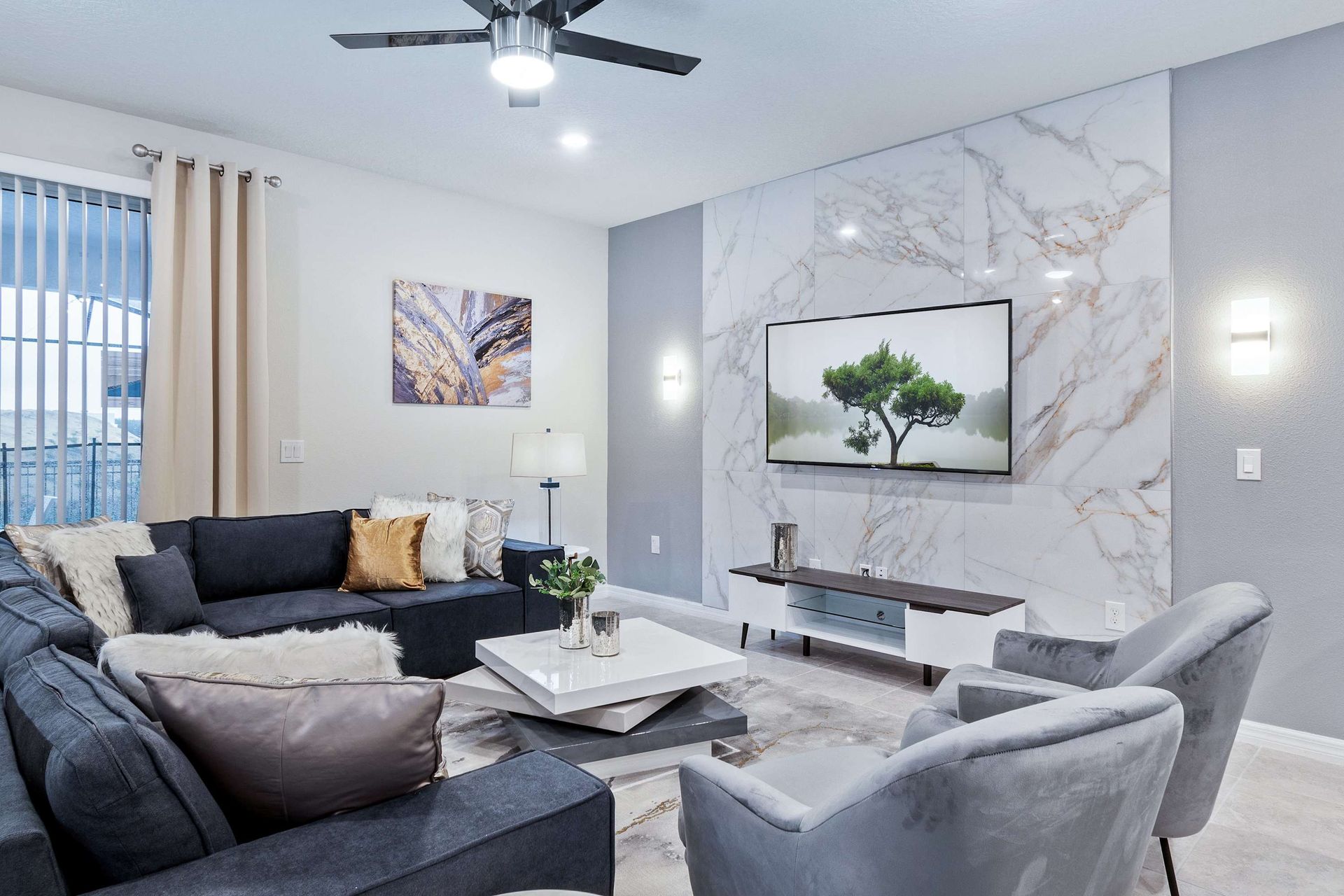 Elegant living area with plush seating, marble accents, and a sleek TV setup.