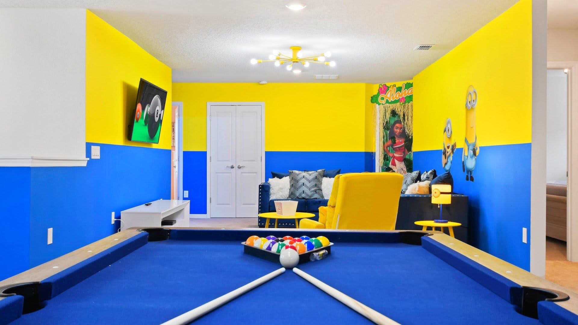 Bright family room with pool table, themed decor, cozy seating, and TV fun!
