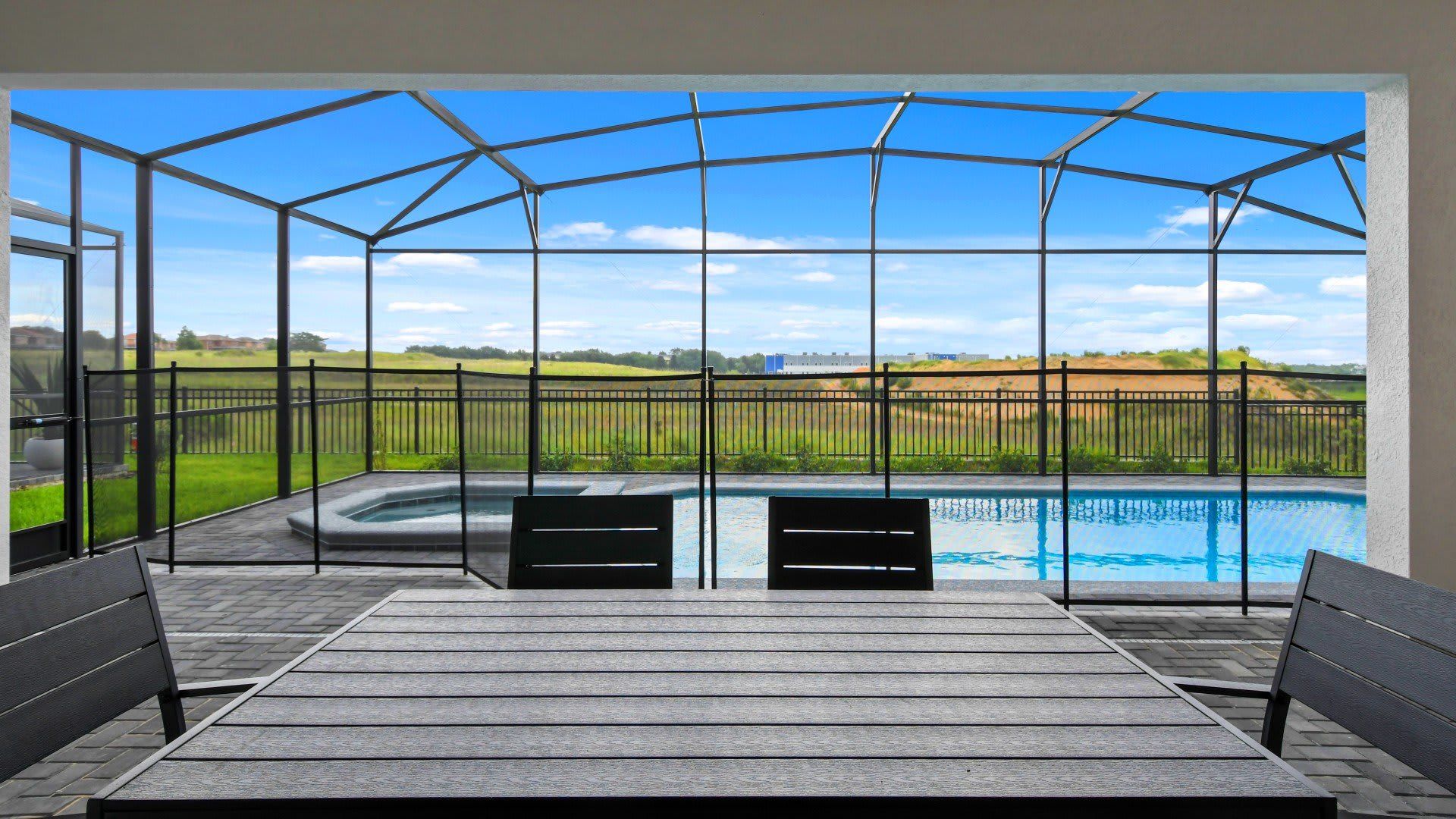 Relaxing screened patio with pool, hot tub, and scenic views of rolling hills!