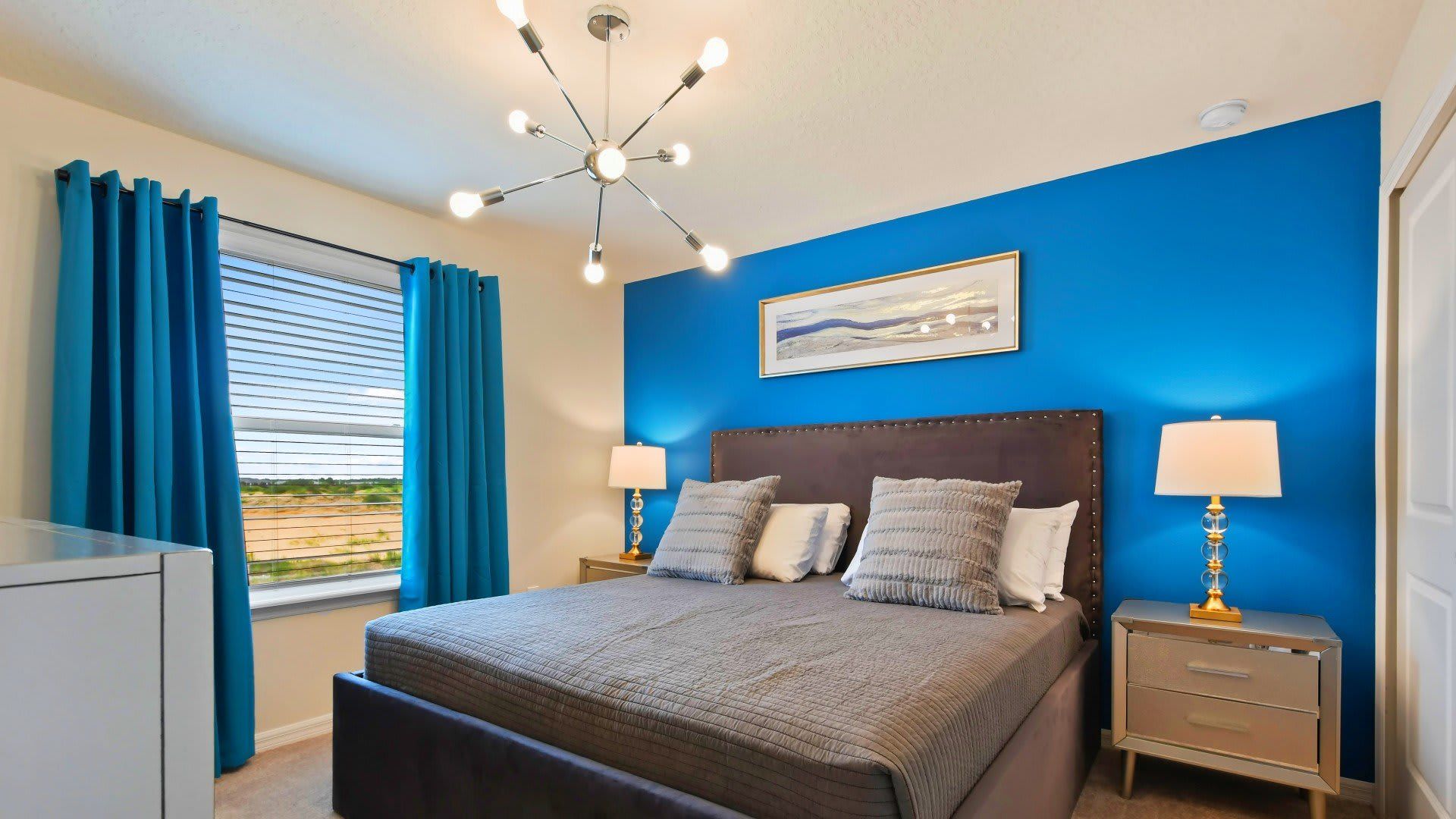 Chic bedroom with bold blue accents, plush bedding, and stylish lighting!