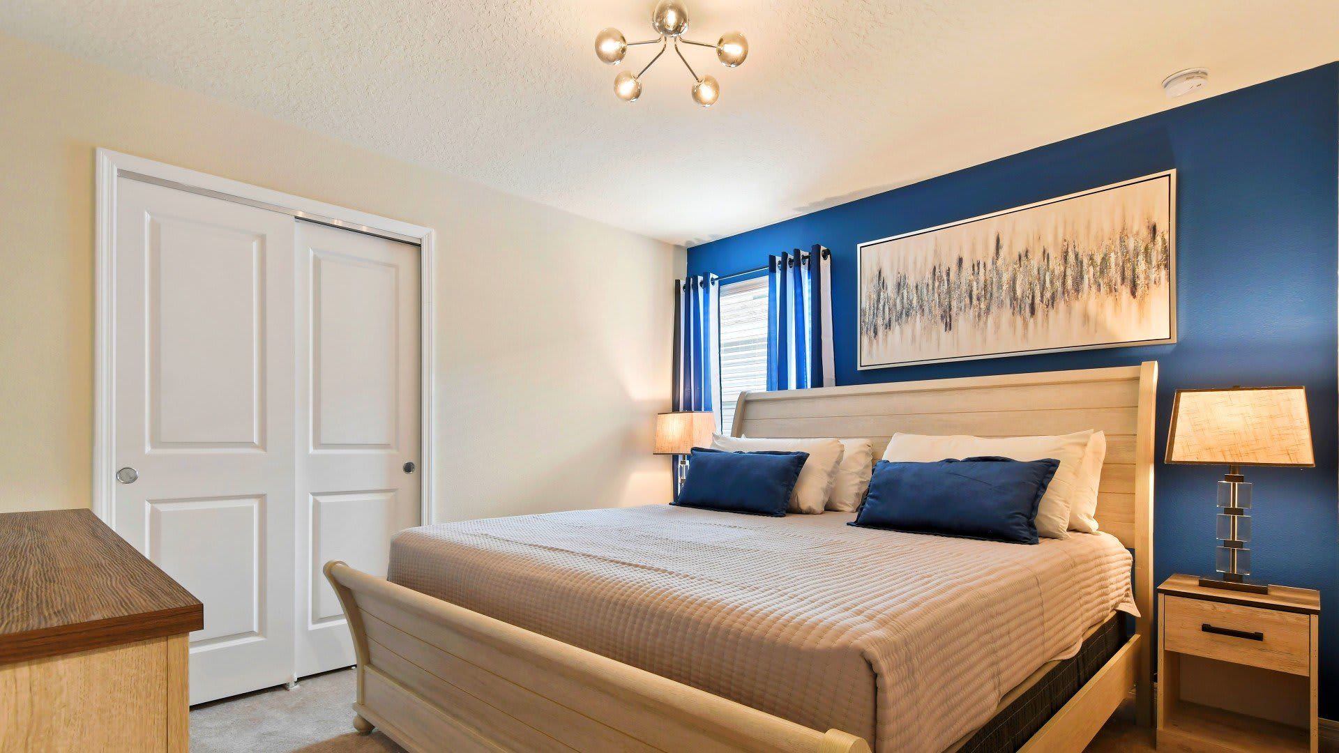 Modern bedroom with cozy bedding, warm lighting, and calming blue accents!