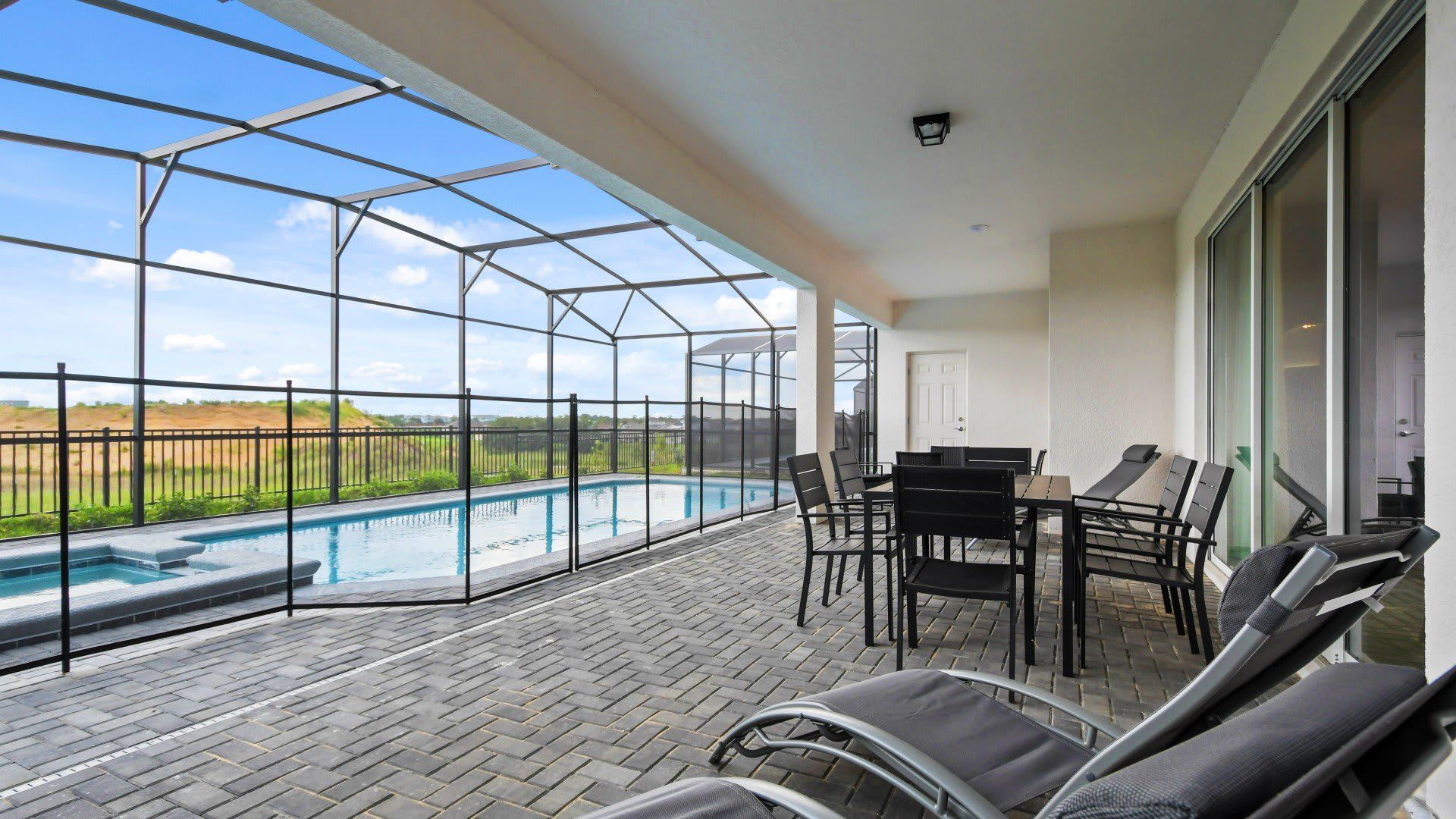 Spacious covered patio with dining area, lounge chairs, and a private pool view!