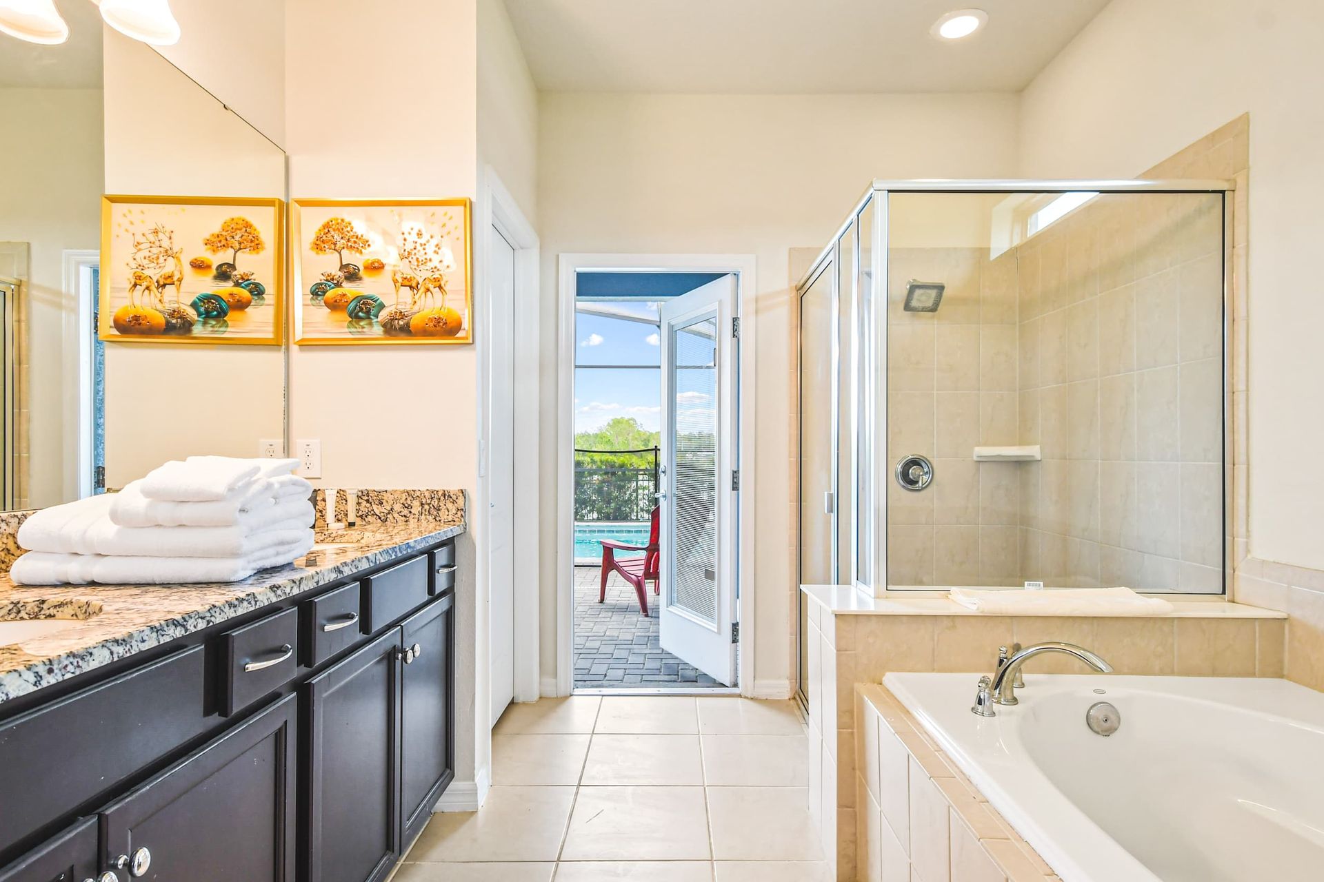 Elegant spa-like bathroom with a soaking tub, walk-in shower & direct pool access!