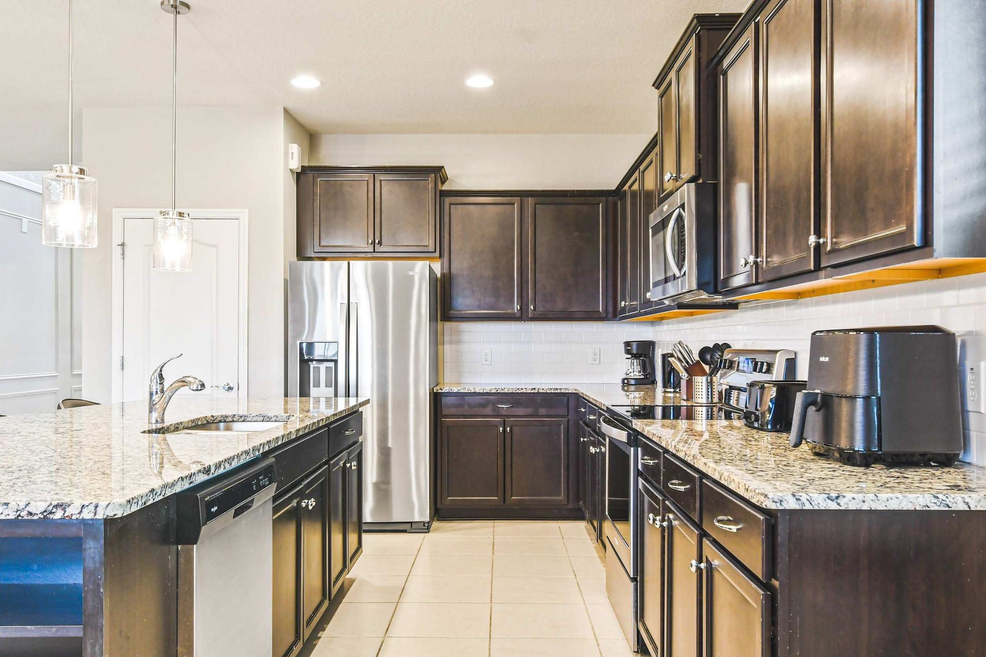 Stylish fully equipped kitchen with granite counters, modern lighting & appliances!
