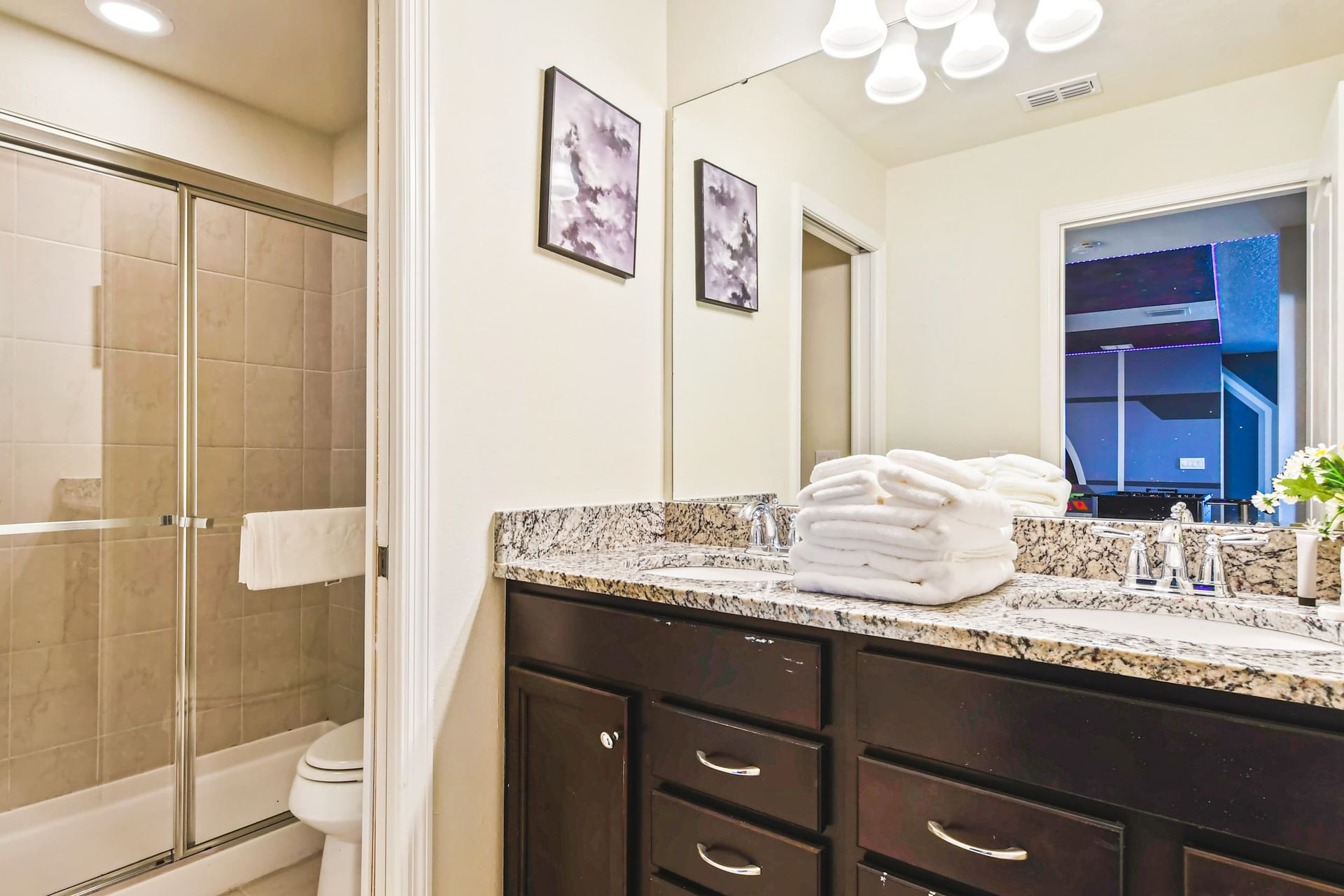 Modern bathroom with dual sinks, granite countertops & a sleek glass walk-in shower!