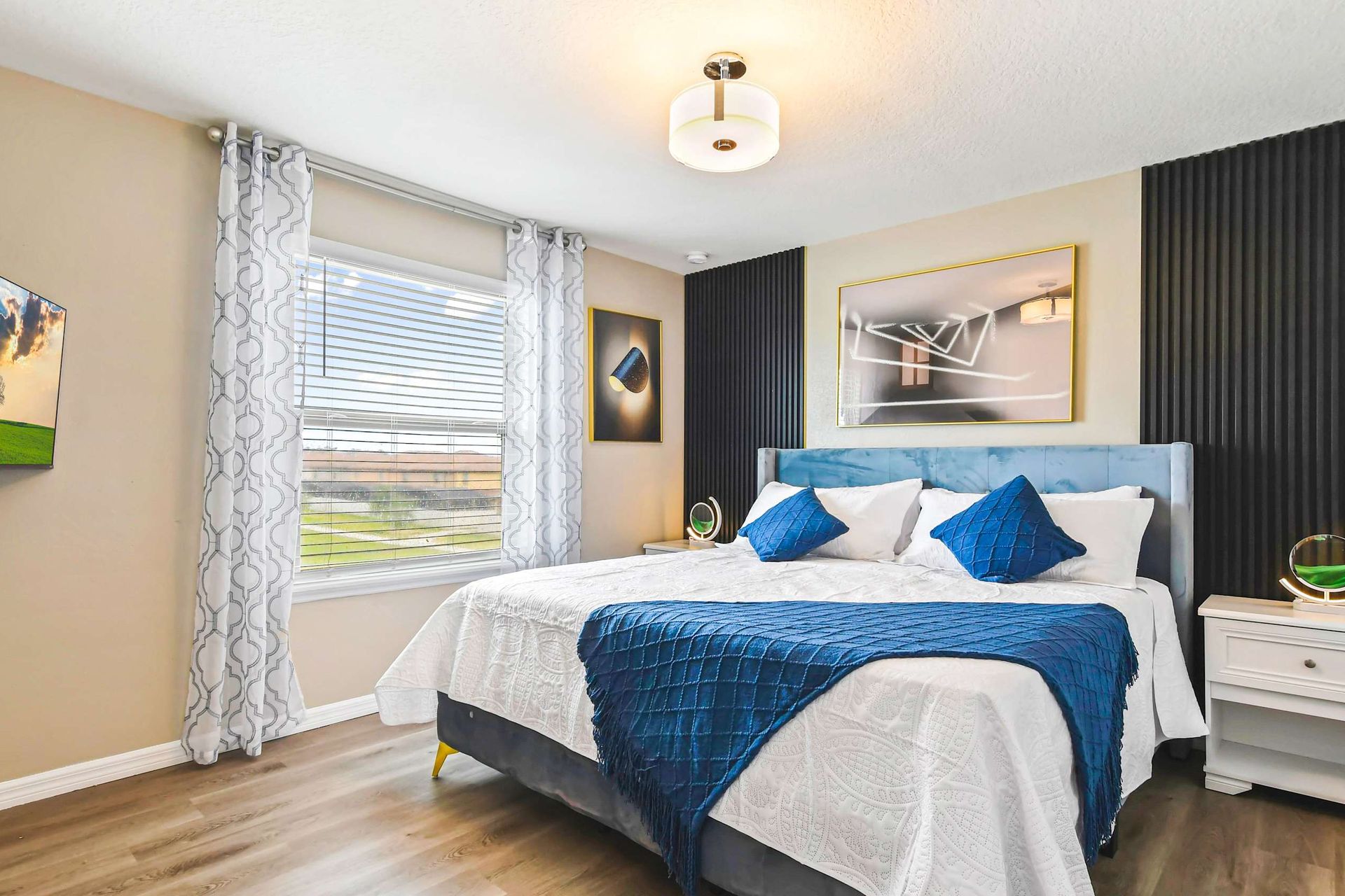Elegant bedroom with bold blue accents, modern lighting & cozy, luxurious bedding!