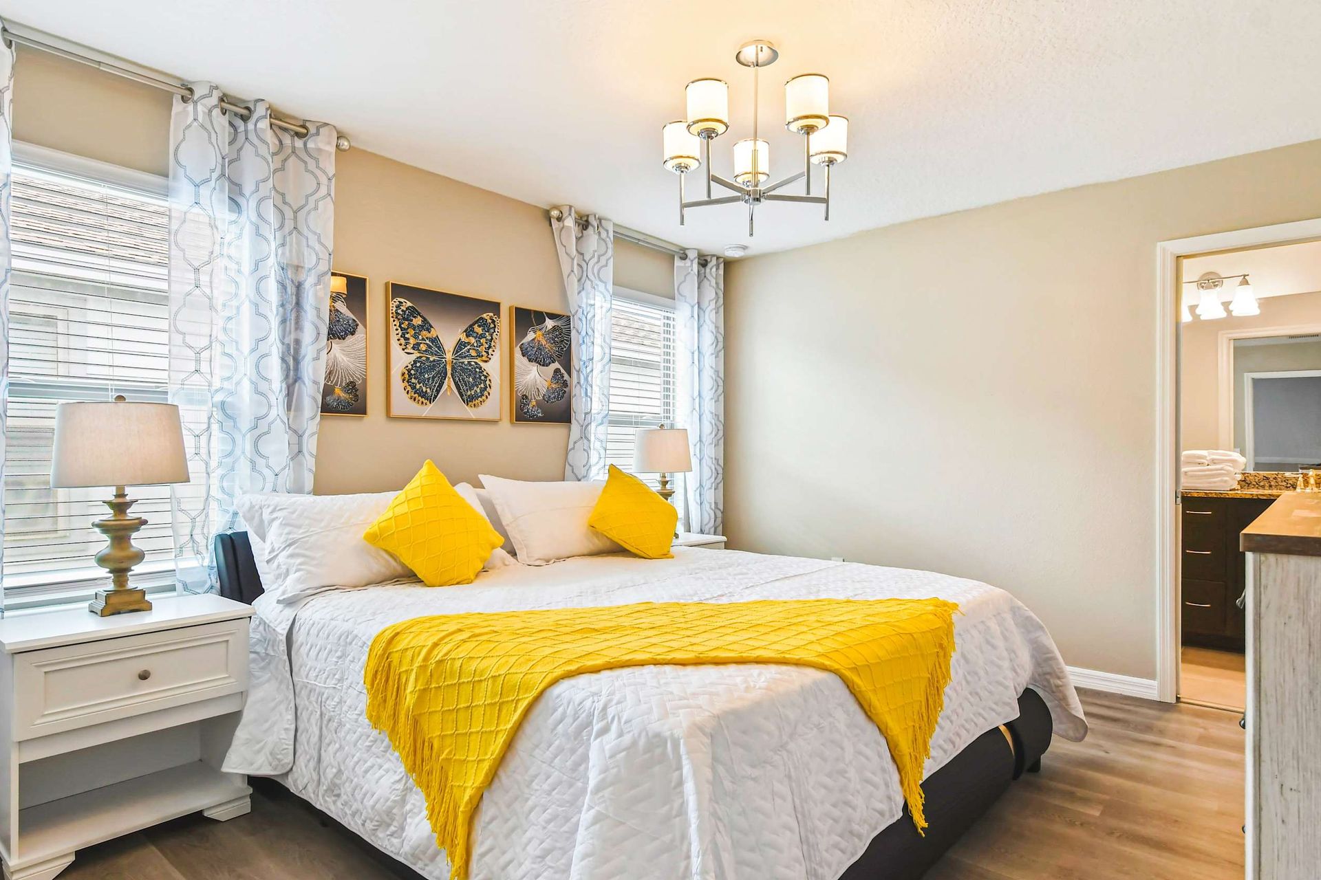 Elegant bedroom with bold yellow accents, modern lighting & cozy, luxurious bedding!