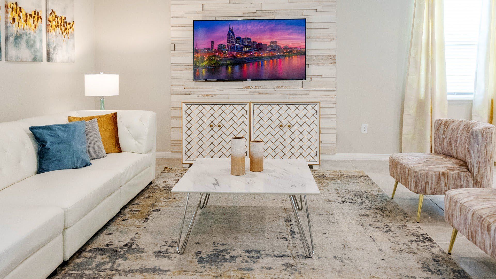 Stylish modern retreat with luxe decor, cozy seating, and a stunning TV setup!