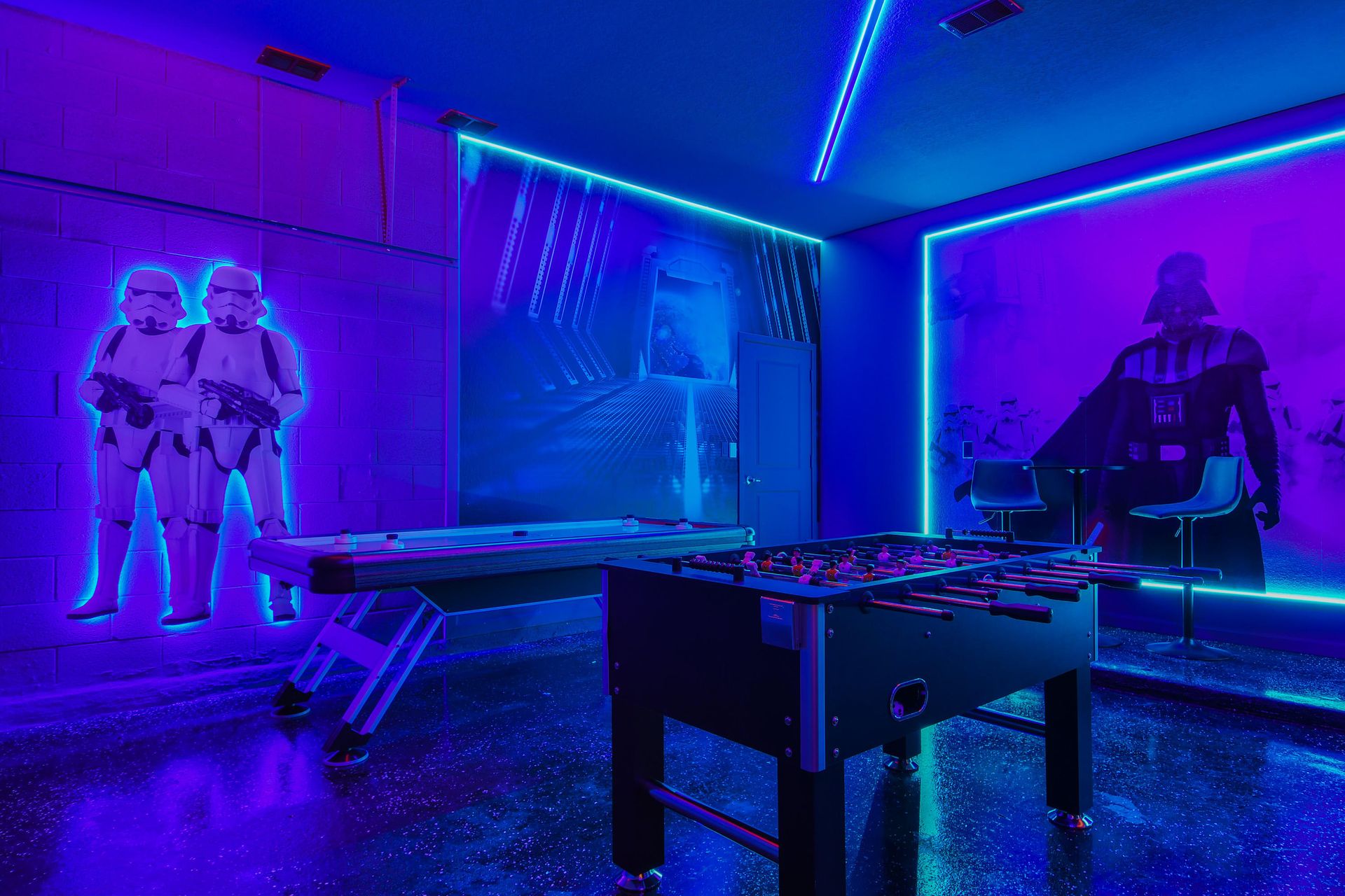 Battle it out in this epic Star Wars game room equipped with a foosball table, neon lights, and space-themed decor.
