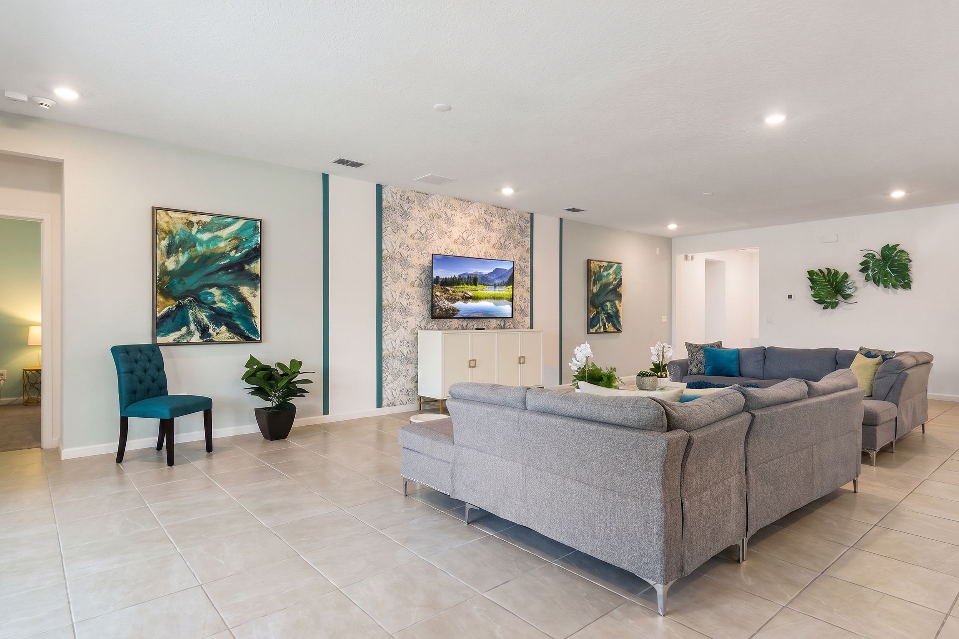 A cozy, open-concept living room featuring a large sectional sofa, contemporary decor, and a wall-mounted TV, idea for relaxation and entertainment.