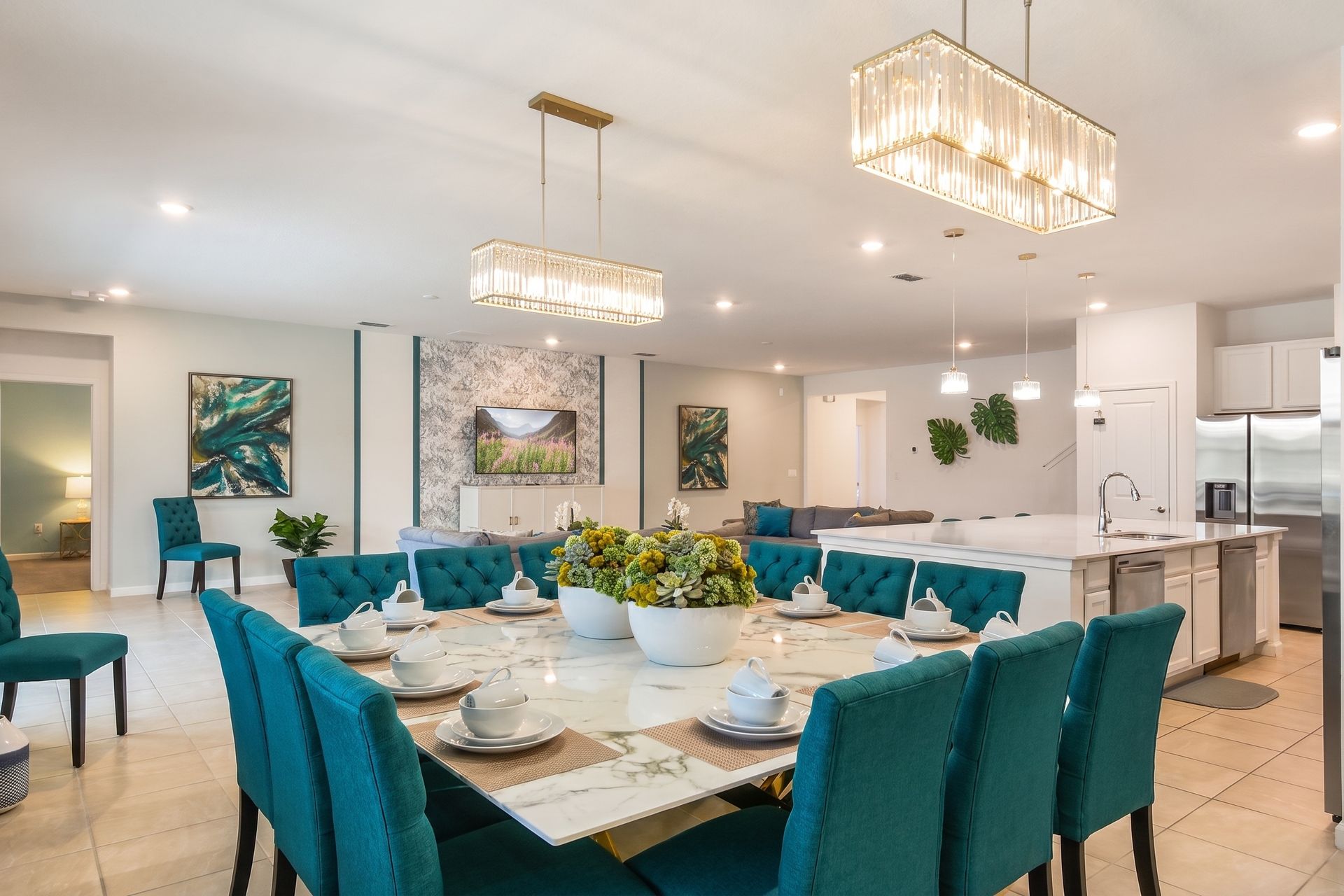 Elegant open-concept dining area with a marble table, plush seating, and chic lighting!