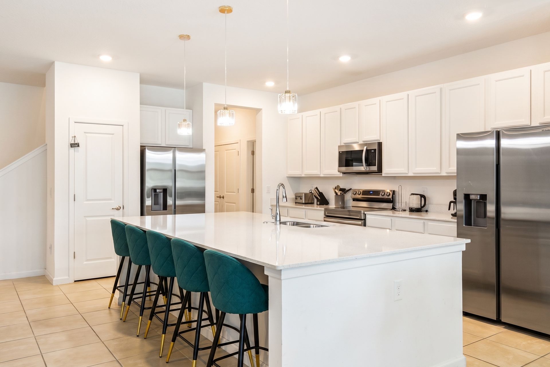 A sleek, modern kitchen with a spacious island, stainless steel appliances, and a breakfast bar with seating for six - perfect for preparing and enjoying family meals.