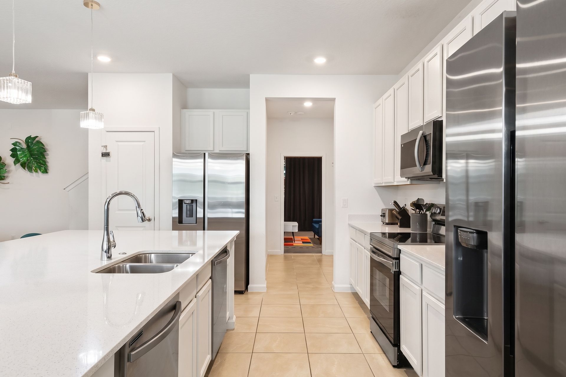 Sleek modern kitchen with stainless steel appliances, a spacious island, and chic lighting!
