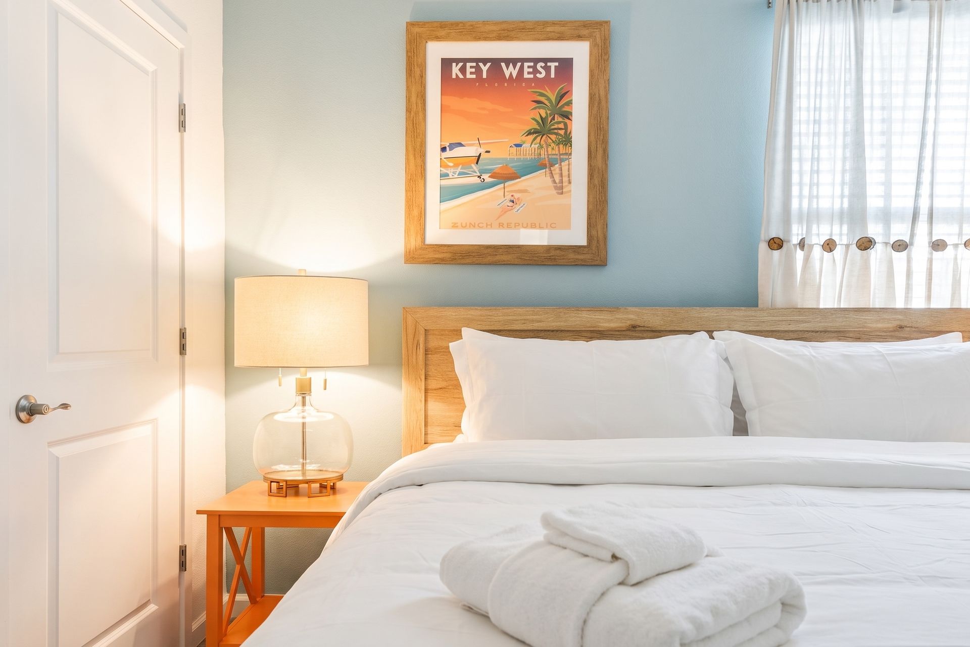 This Key West-inspired bedroom has a warm, coastal charm with its soft blue-green accent wall
