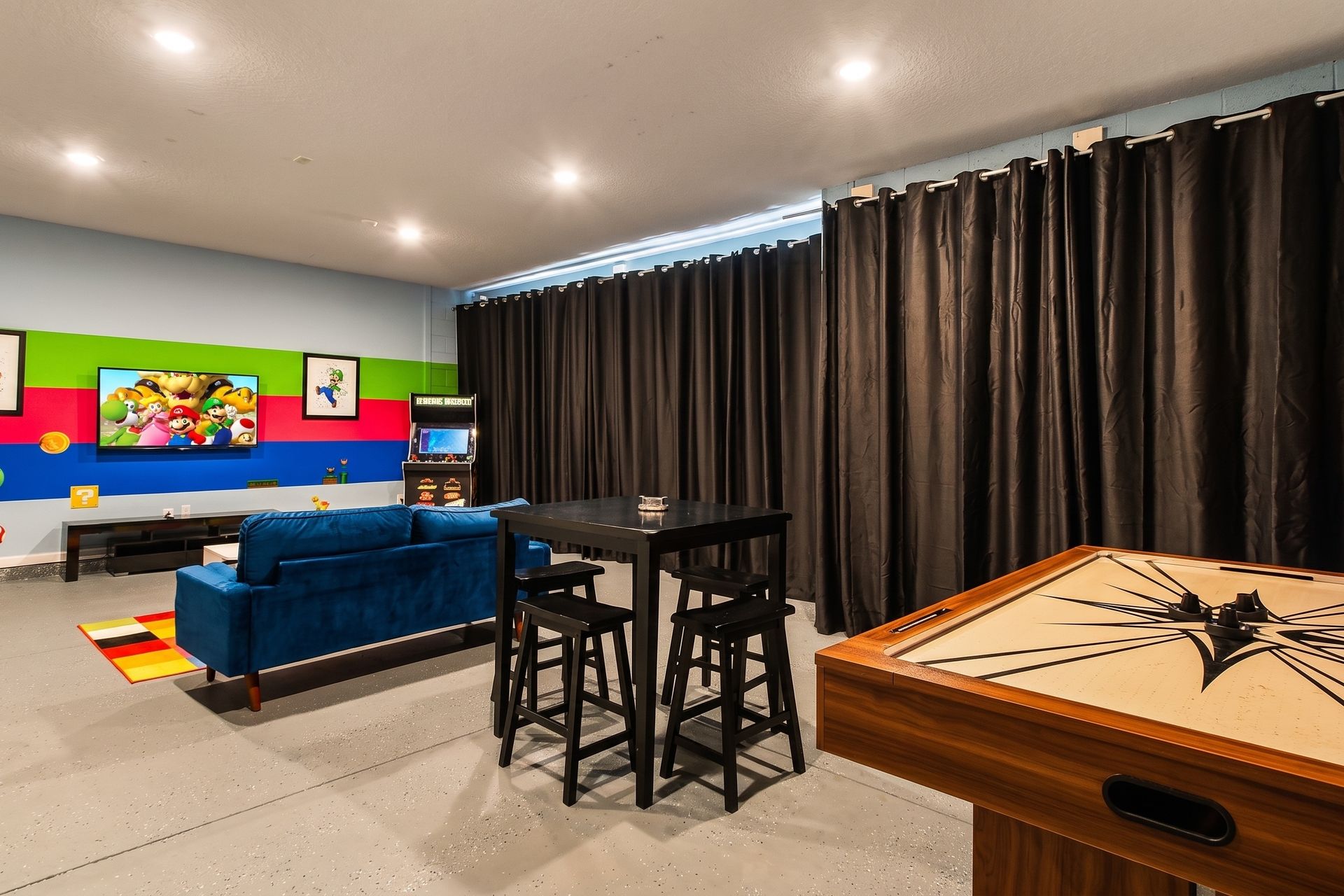 Exciting game room with arcade games, air hockey, and a fun Mario-themed design!