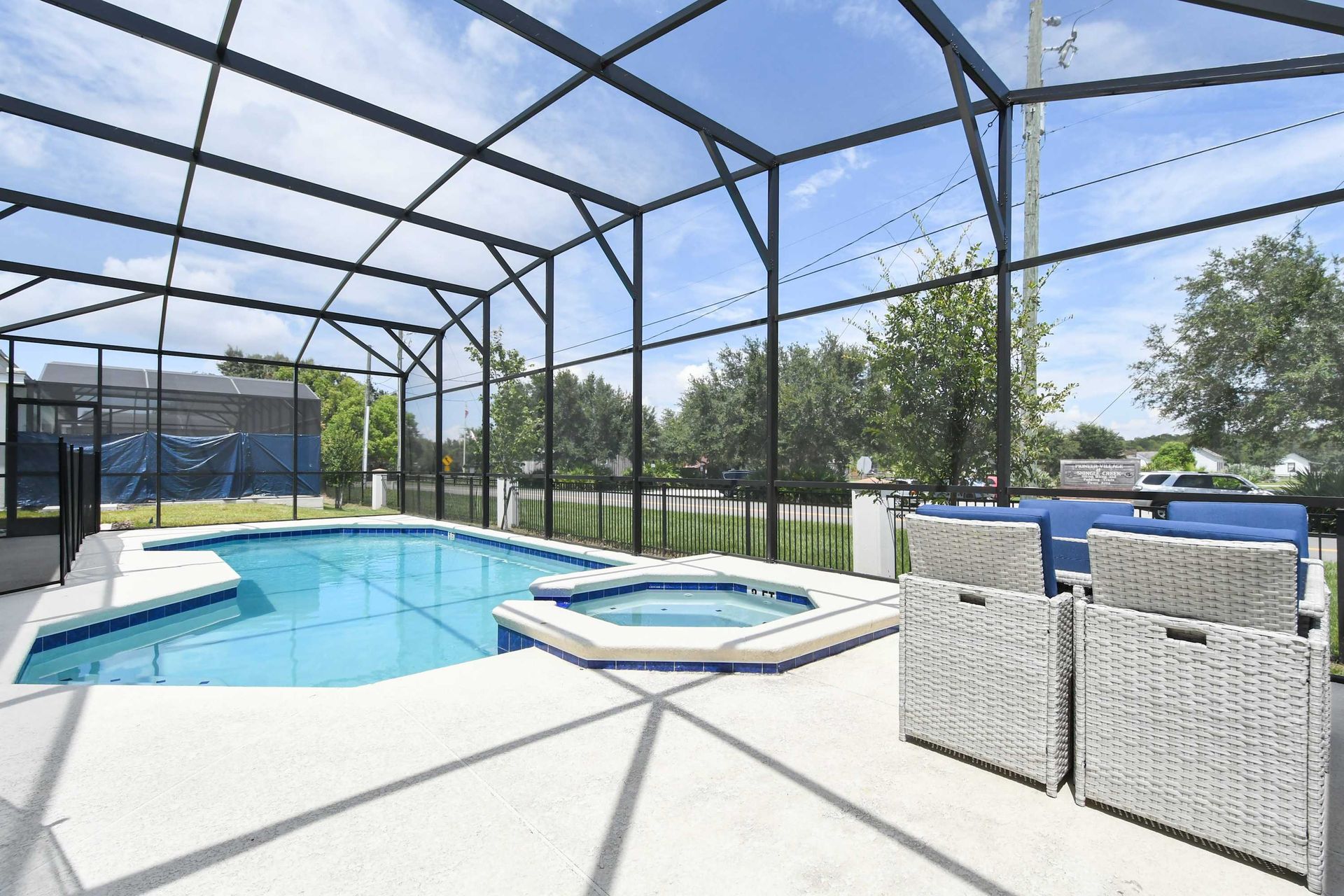 A private outdoor pool enclosed by a screen,complete with a cozy lounge area, hot tub, and ample seating - ideal for relaxing under the sun near Disney.