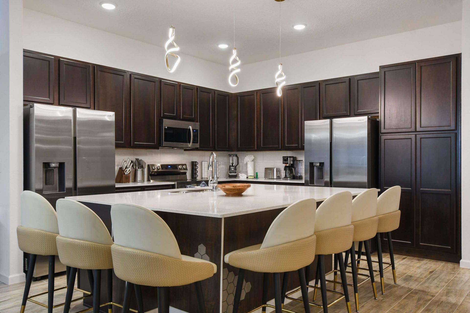 Luxury kitchen with dark wood cabinetry, sleek appliances, and a spacious island.