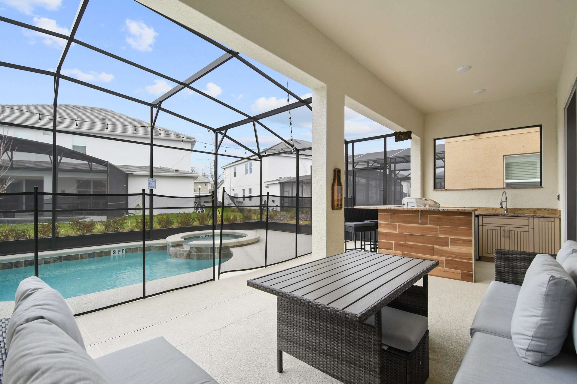 Covered patio with outdoor seating, private pool, spa, and a stylish bar area.