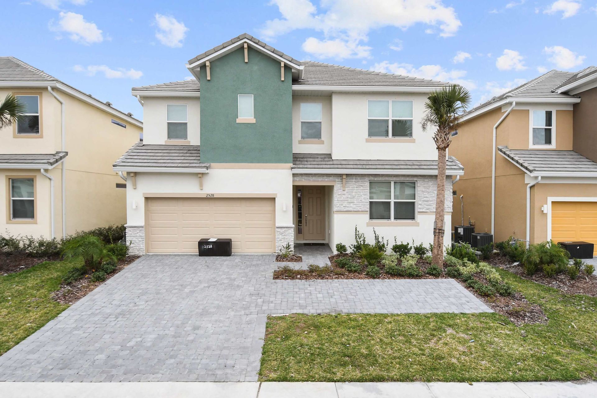 Modern luxury villa with a spacious driveway, elegant design, and beautifully landscaped yard.