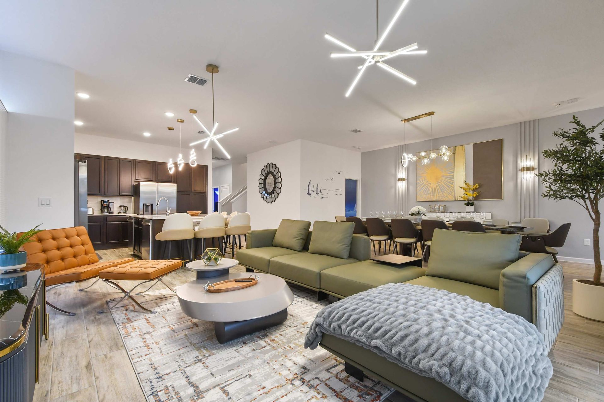 Spacious modern living area with stylish decor, open kitchen, and elegant lighting.