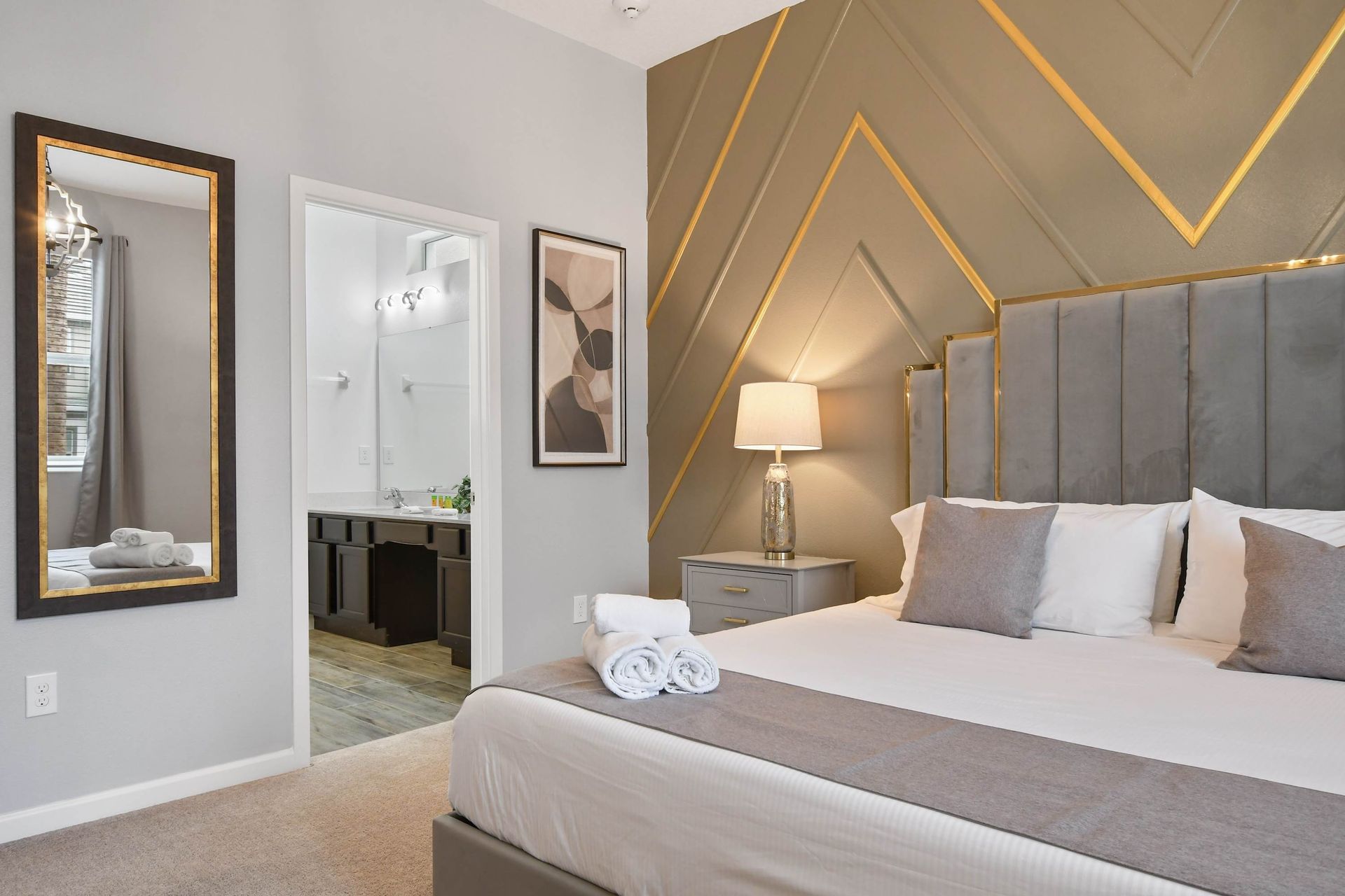 Luxurious master bedroom with elegant decor, plush bedding, and a stylish accent wall.