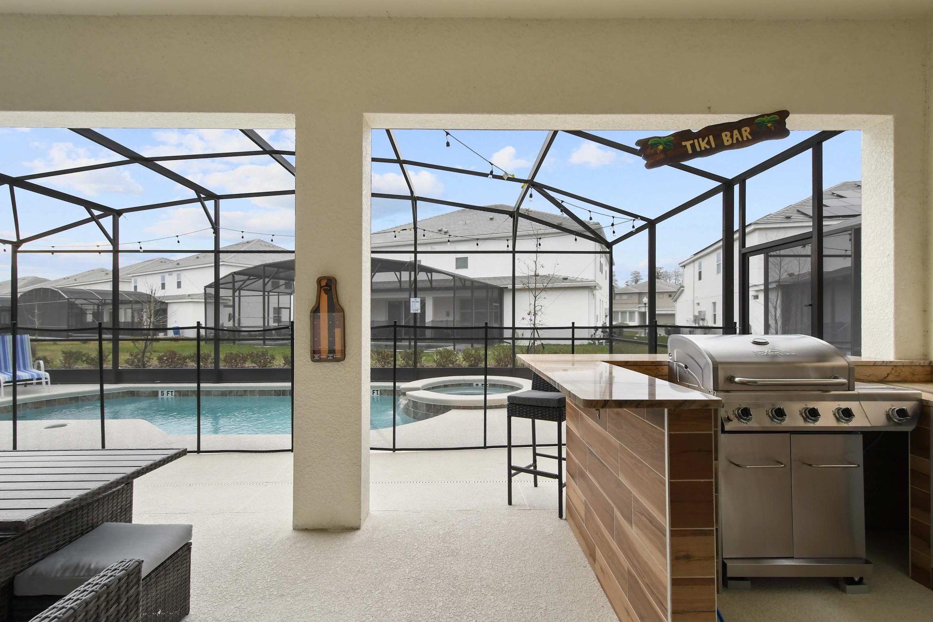 Covered patio with outdoor seating, private pool, spa, and a stylish bar area.
