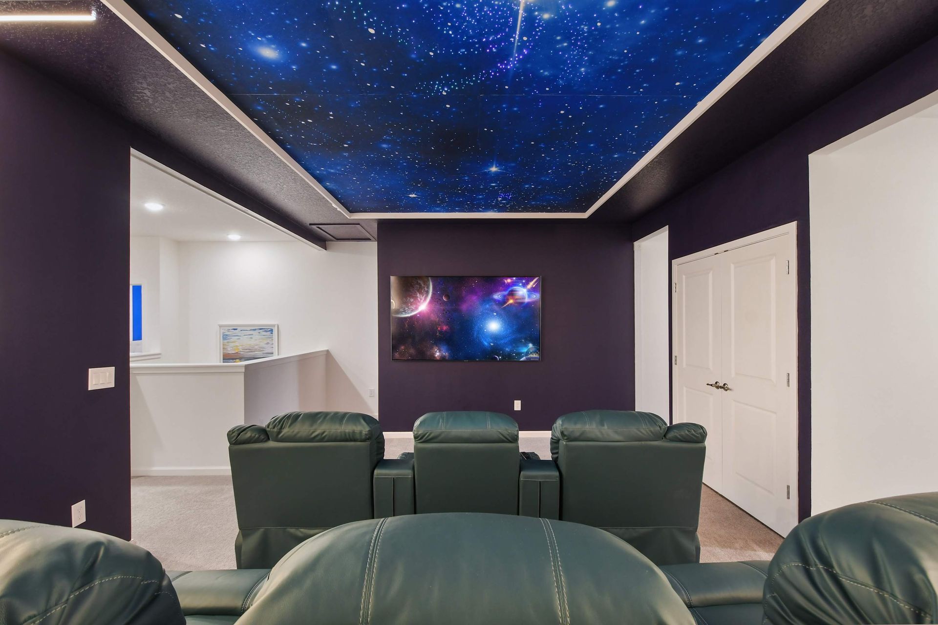 Luxury home theater with reclining seats, starry ceiling, and immersive lighting design.